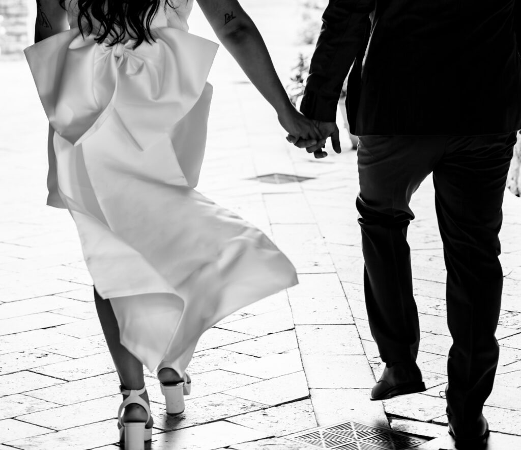 Black and White of couple holding hands at The Club at Bella Collina