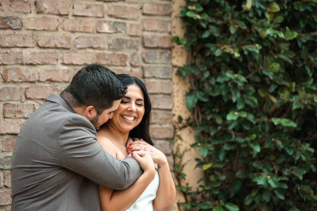 Couple snuggling at engagement session at bella collina 