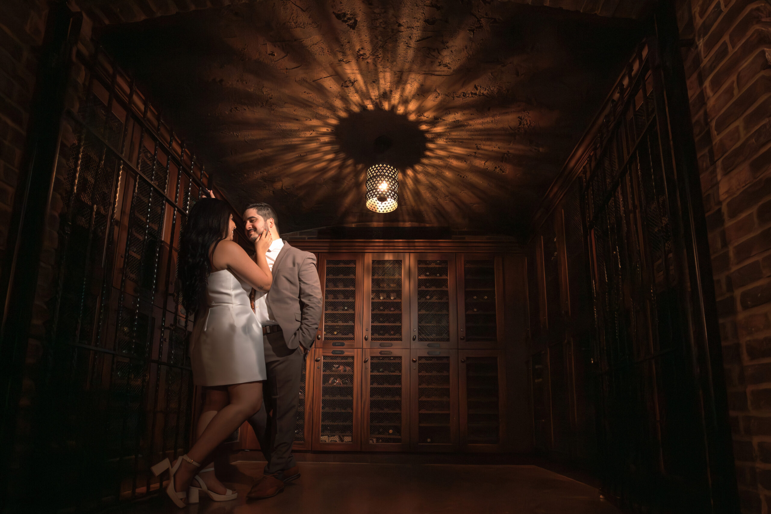 Bride holding groom inside wine cellar at Bella Collina wedding venue