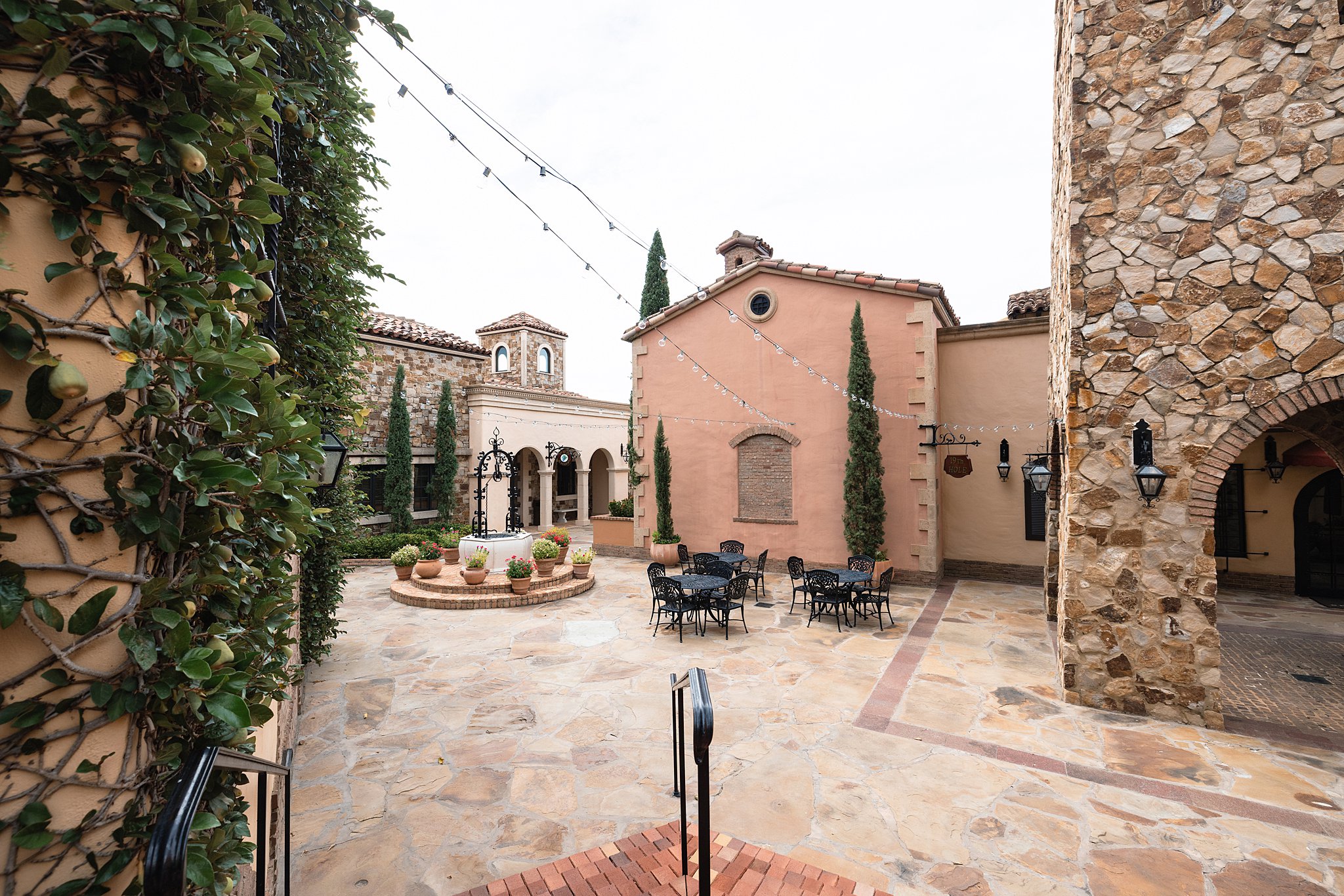 A view of the the club at bella collina wedding patio with market lights and a well