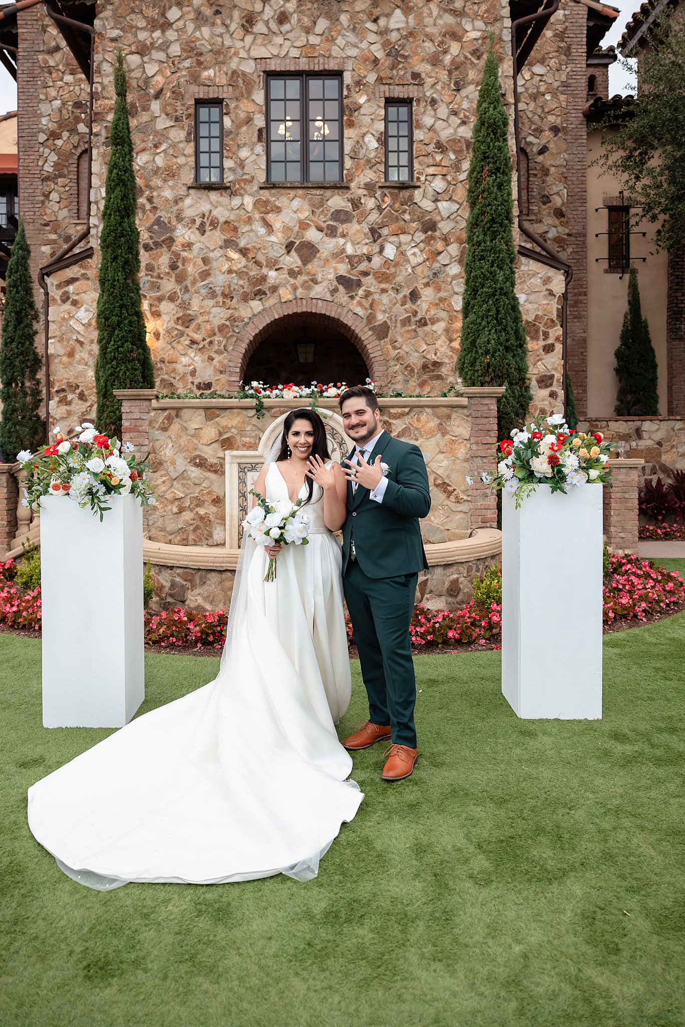 Newlyweds show off their rings in a garden lawn wedding ceremony location