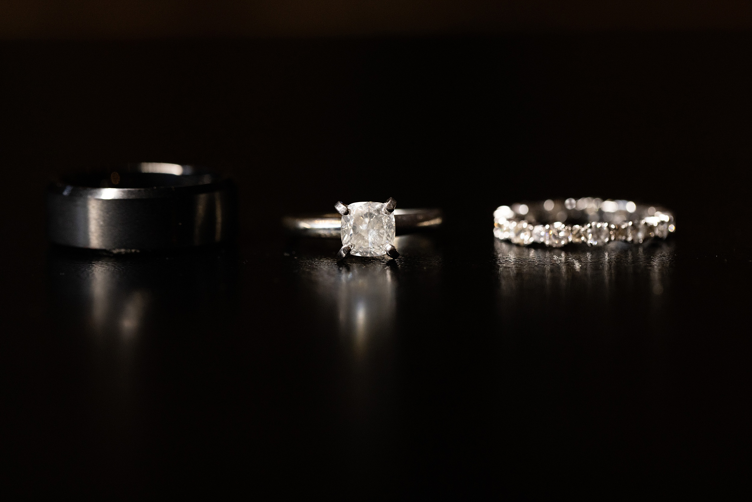 Details of wedding rings sitting on a black table