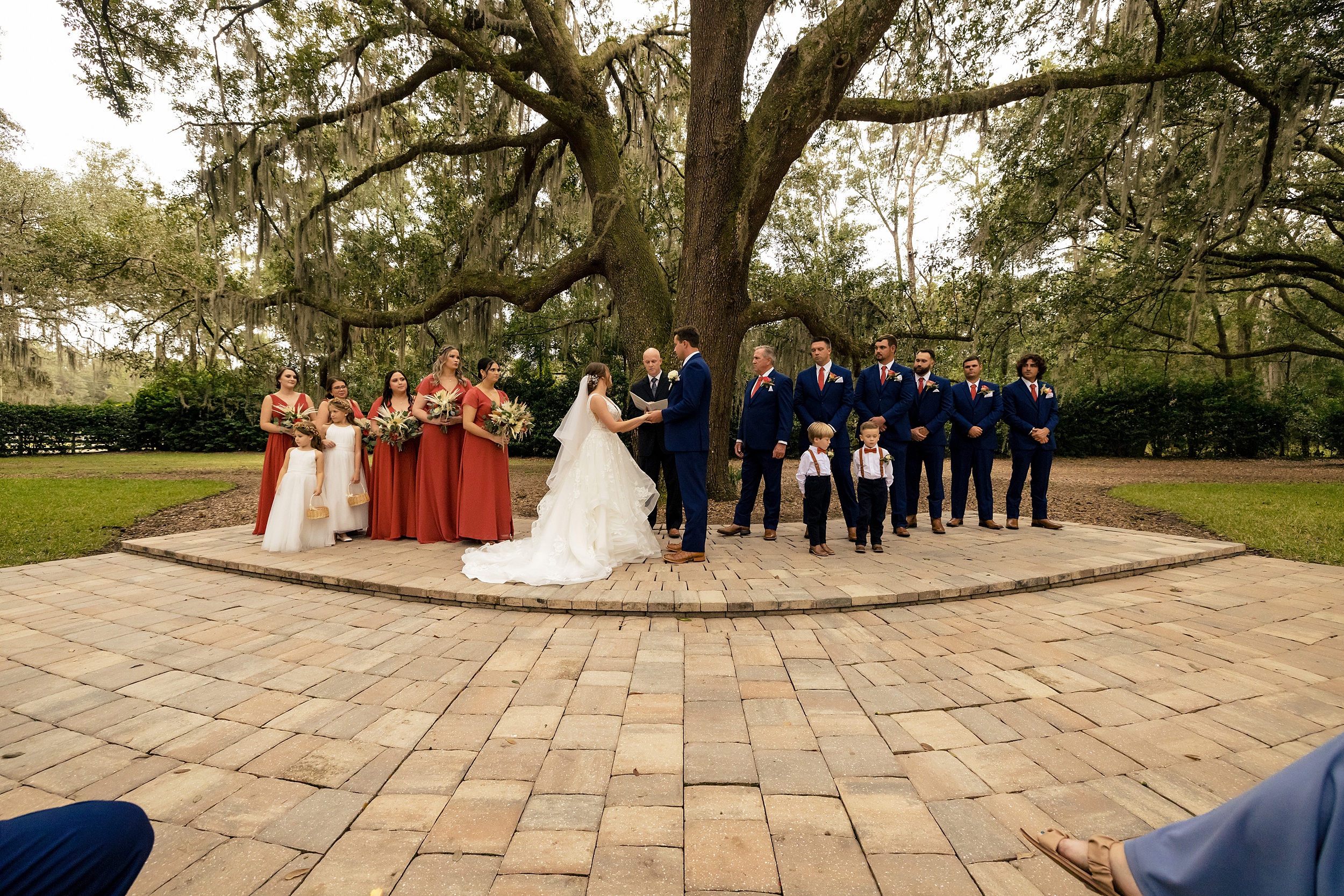 Newlyweds hold hands at the altar of their outdoor wedding ceremony