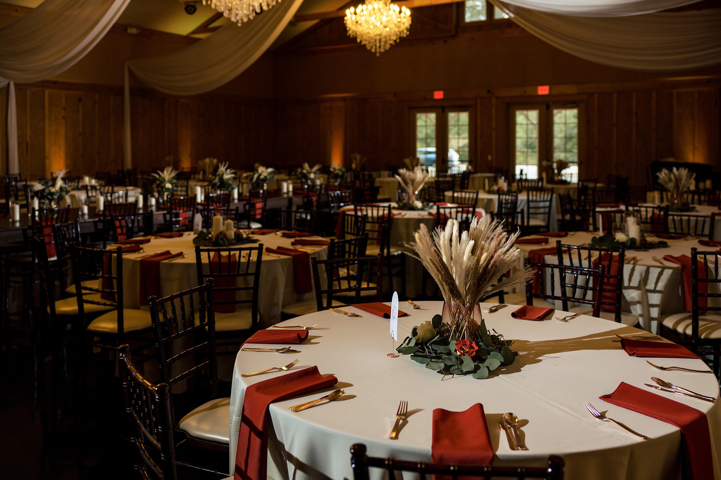 A bowing oaks wedding reception set up with white linens and red napkins