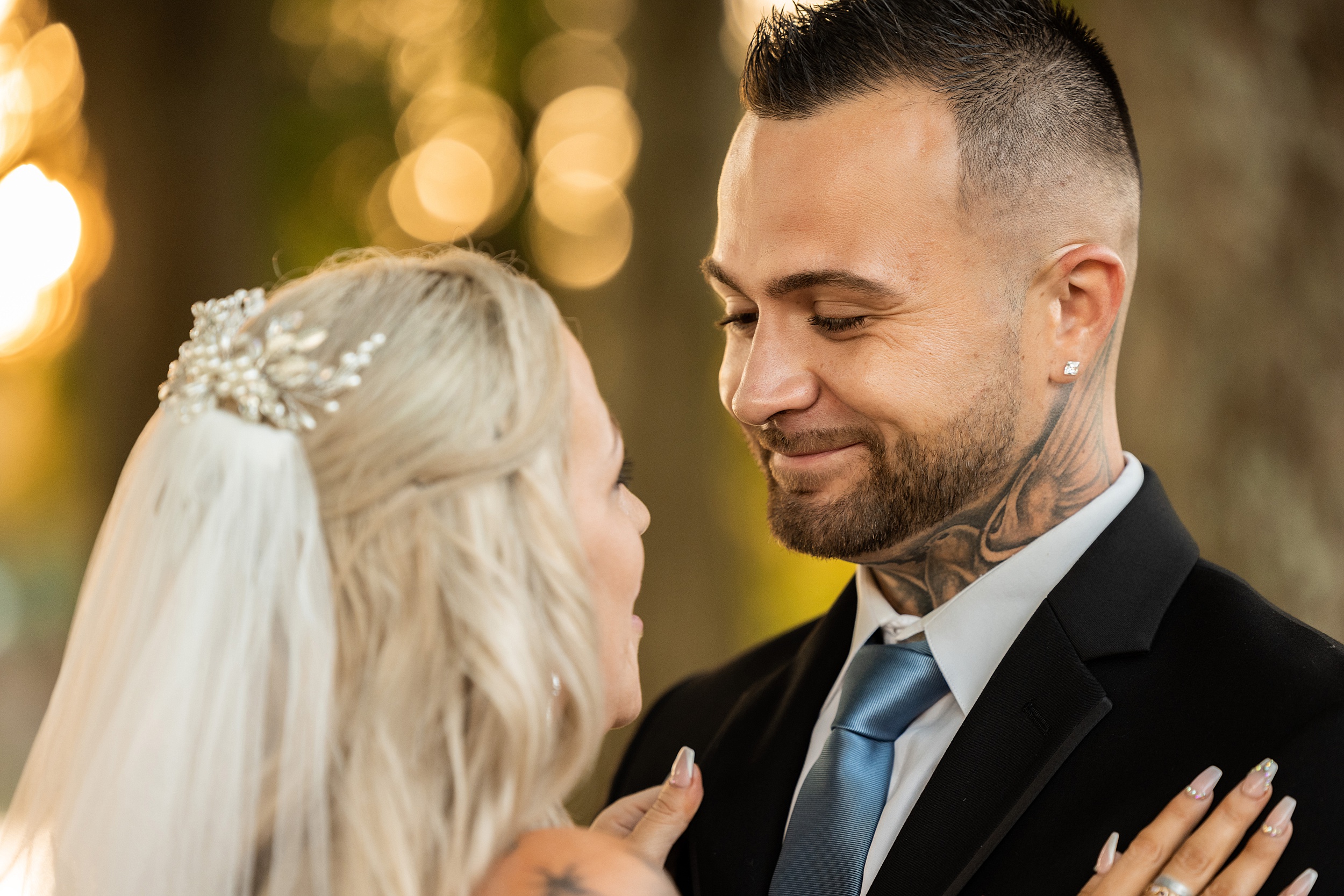 Newlyweds smile at each other while standing close at their chandler oaks barn wedding