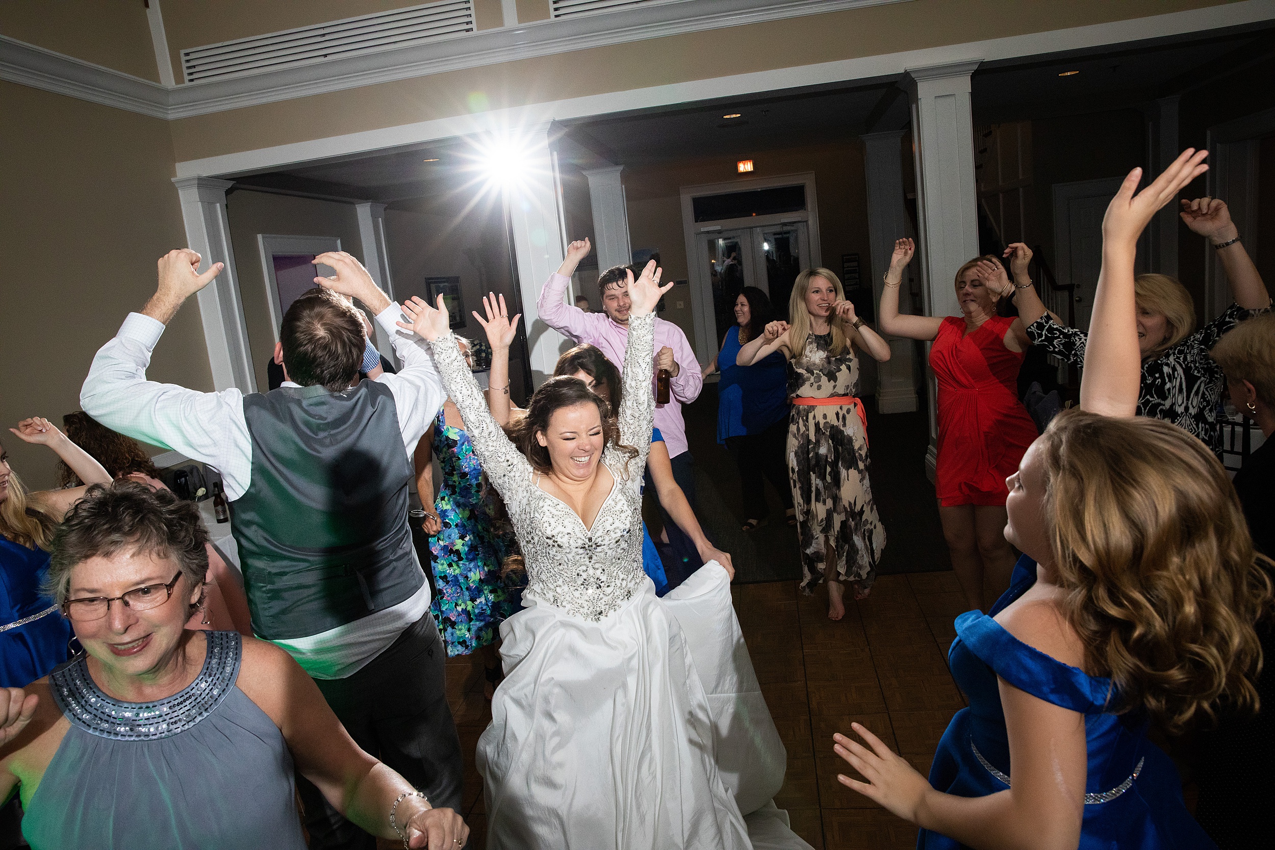 Newlyweds dance wildly surrounded by guests dancing with them at their deercreek country club wedding reception