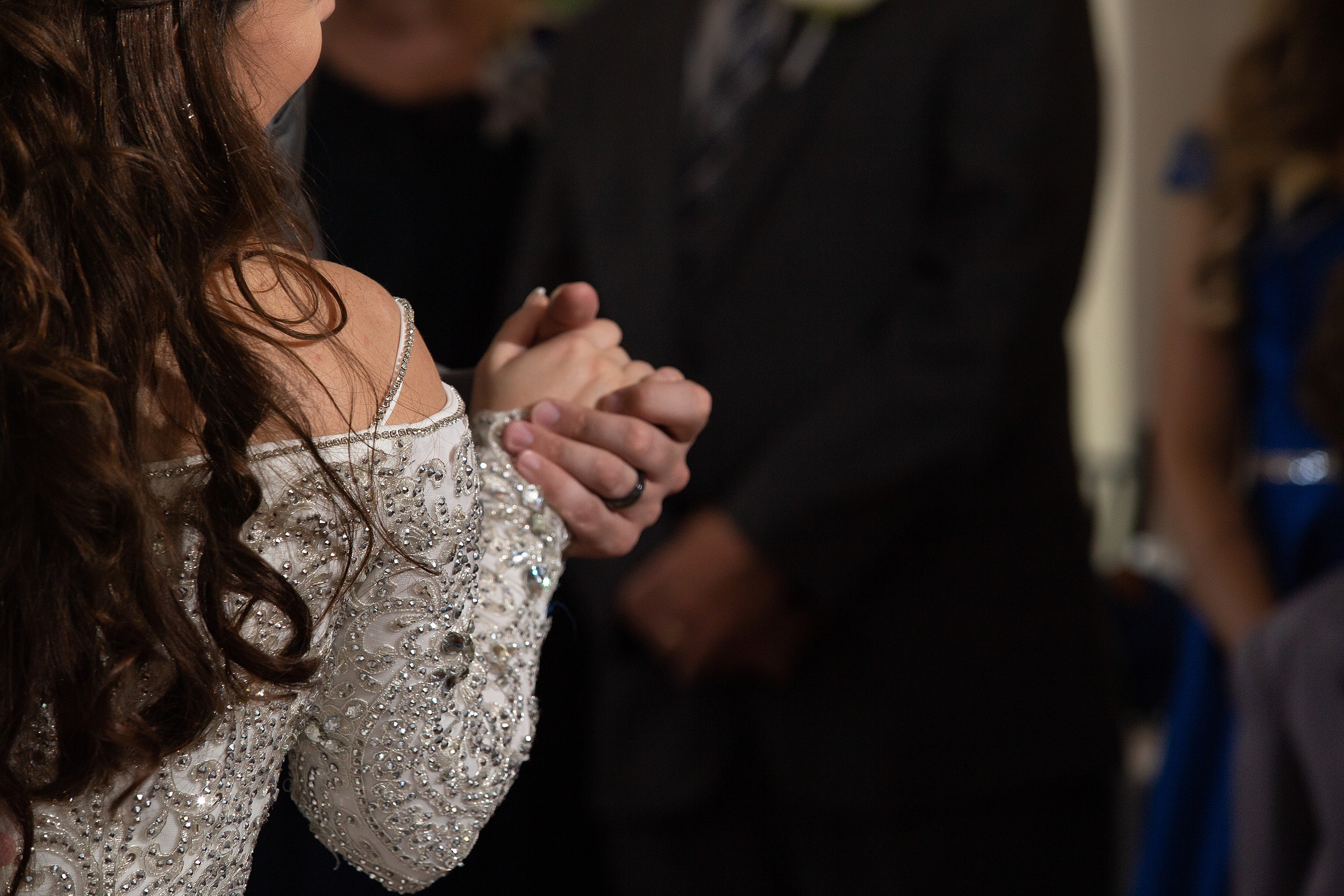 Details of newlyweds holding hands during a wedding reception dance