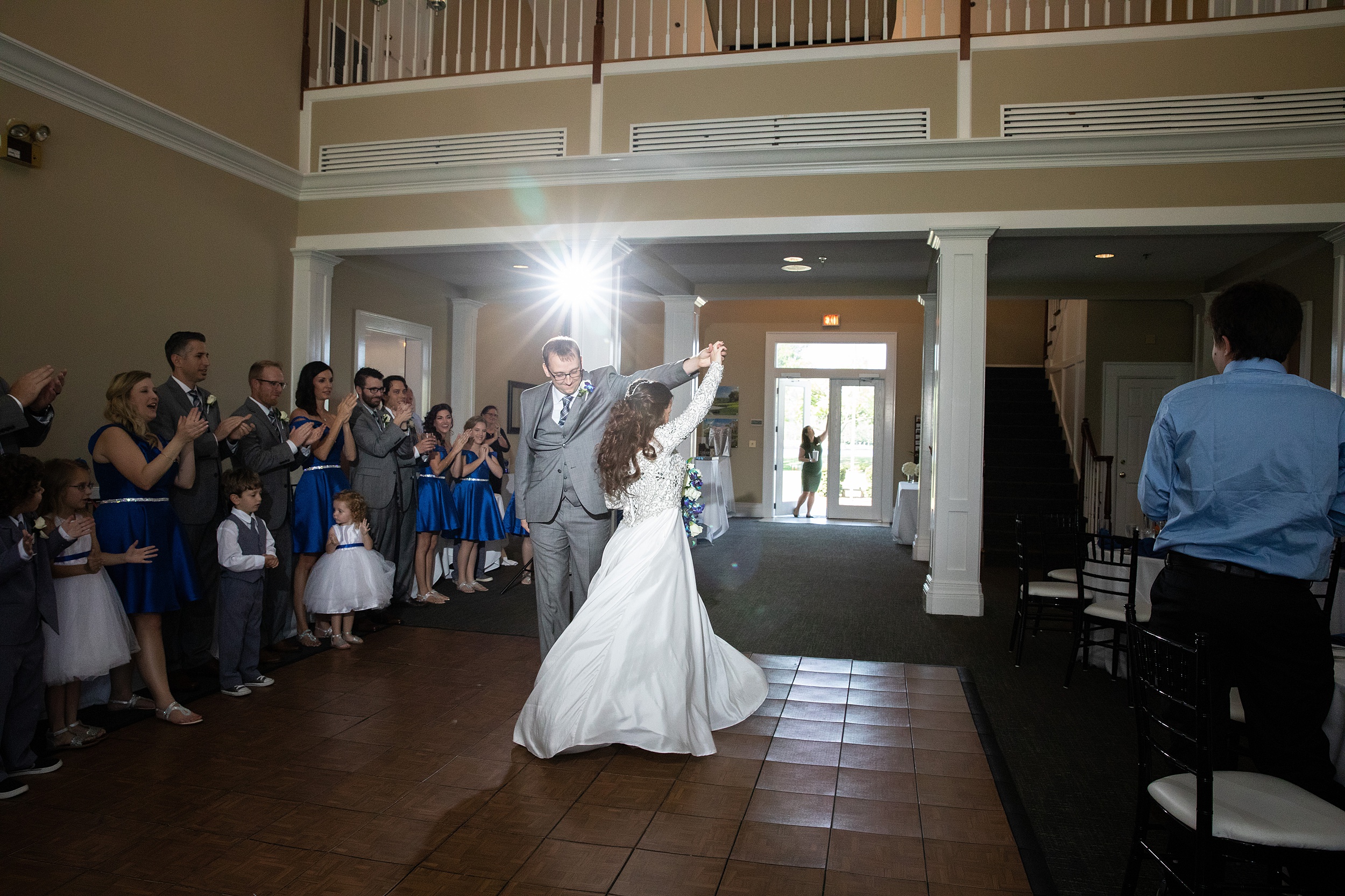 A groom twirls his bride while dancing at their deercreek country club wedding reception