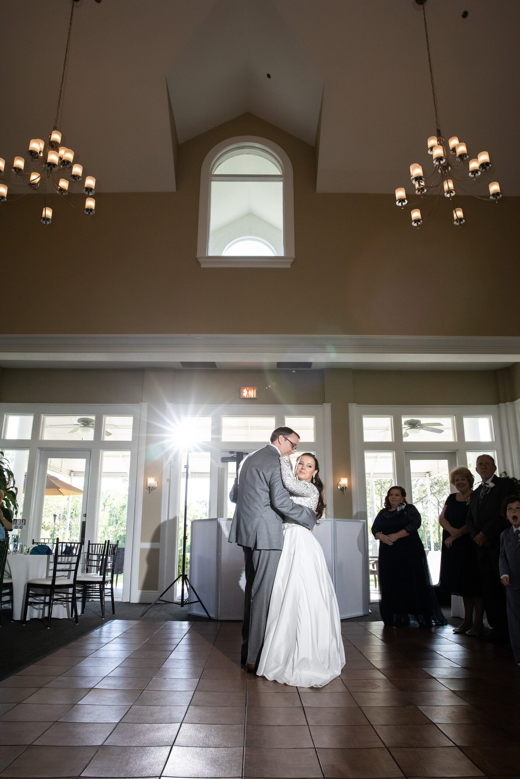 Newlyweds dance for the first time on the dance floor at their deercreek country club wedding reception surrounded by guests