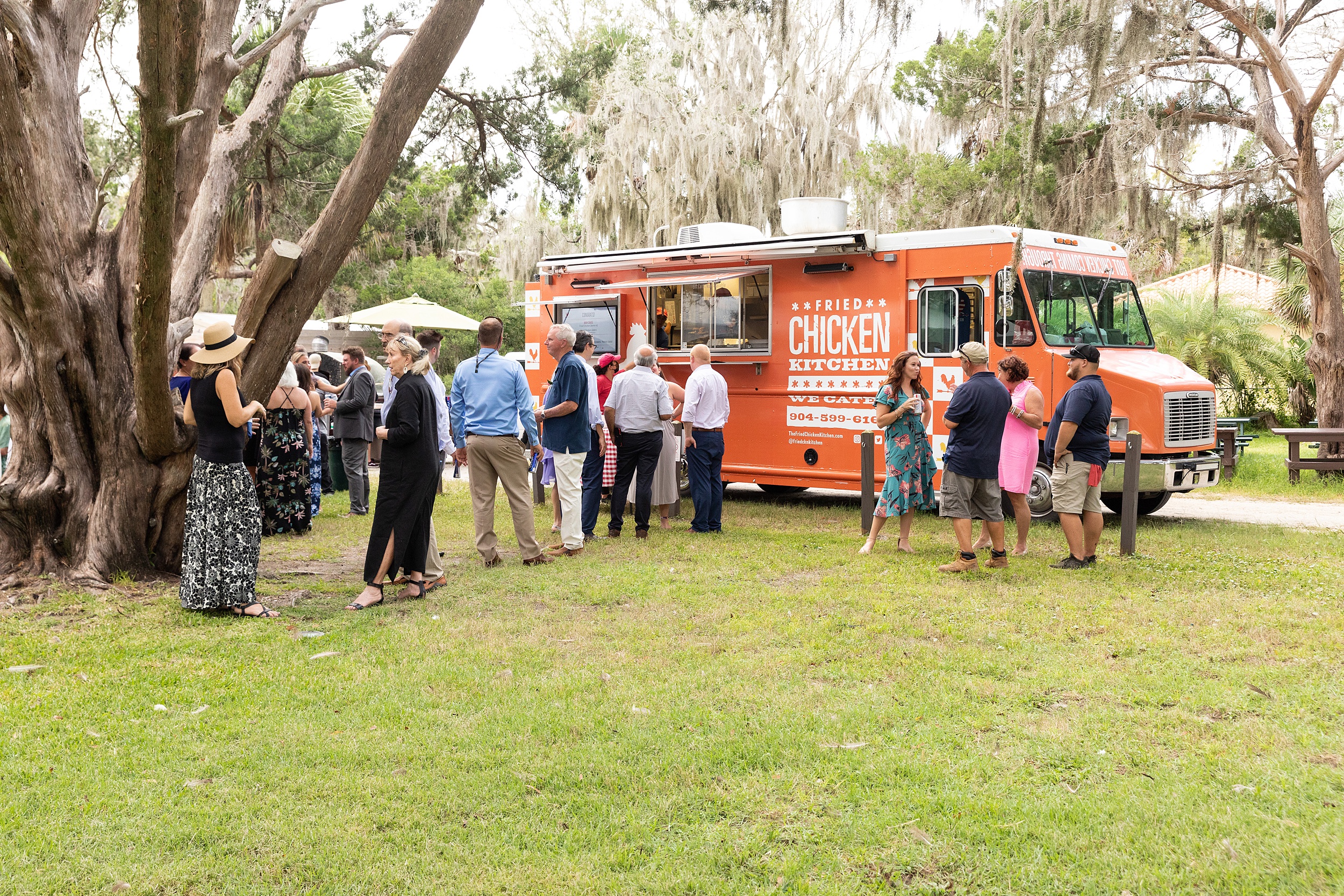 Details of guests enjoying a fried chicken food truck at a wedding reception