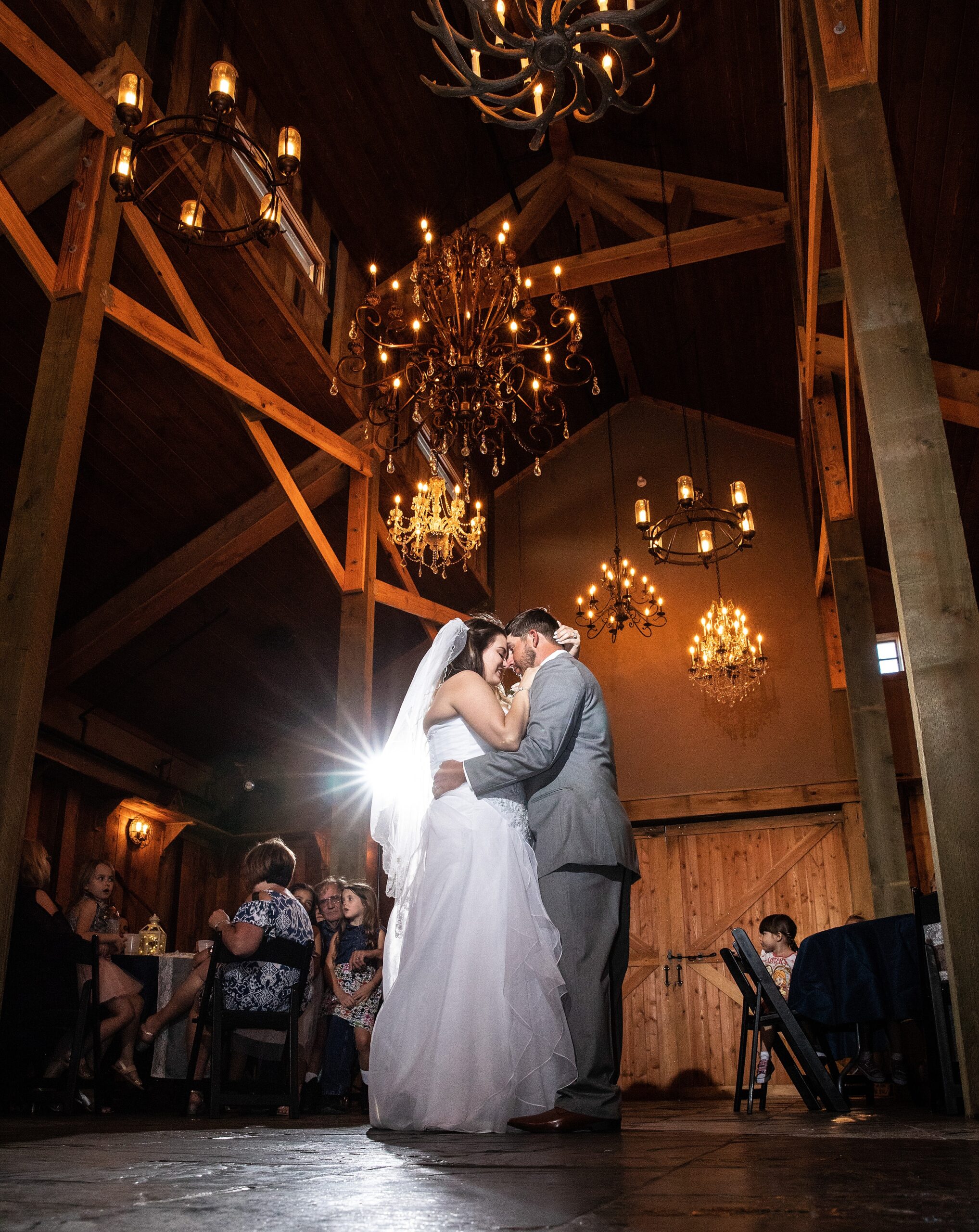 Newlyweds dance holding each other close under chandeliers in a historic grant station wedding