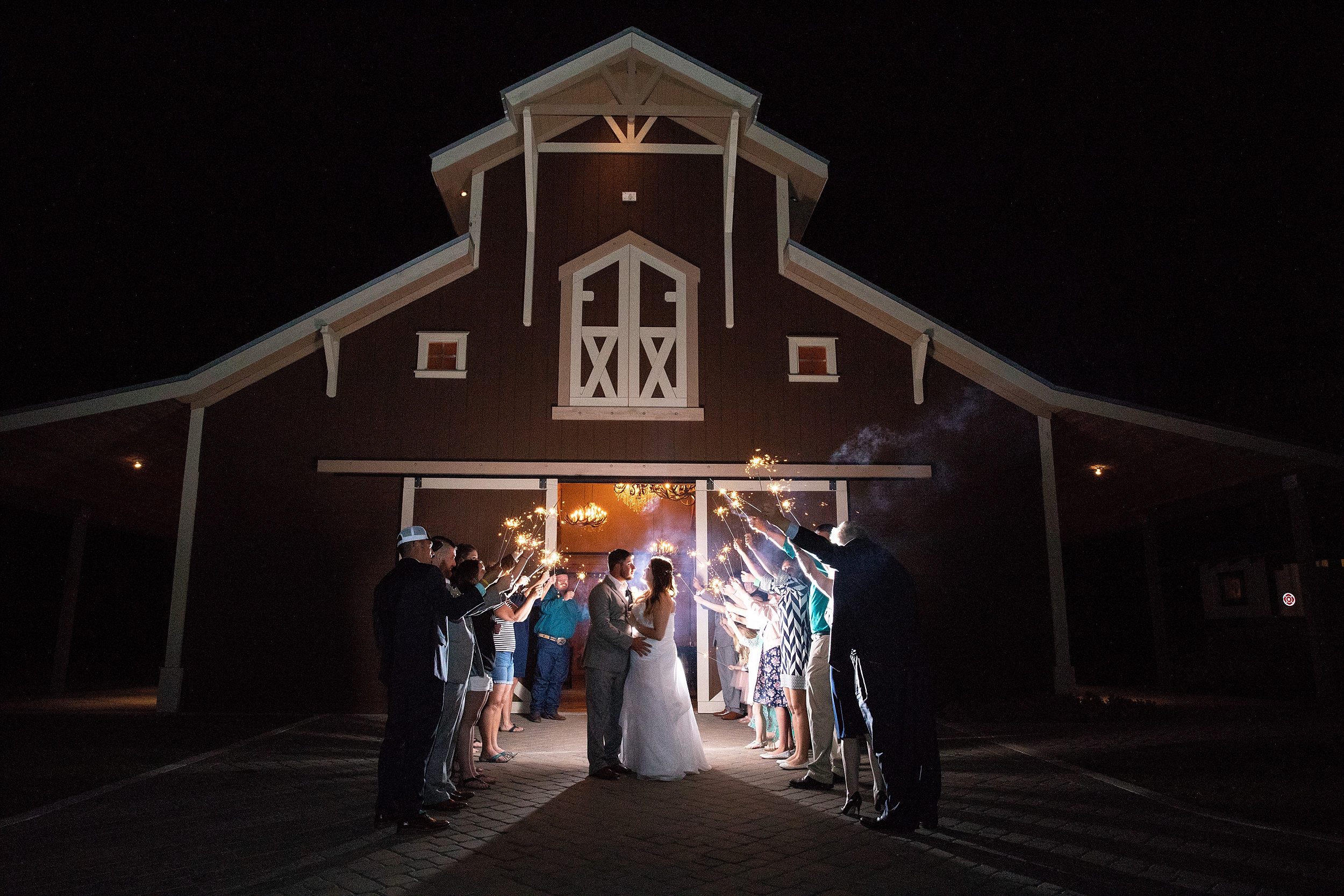 Newlyweds lean in for a kiss under an archway of sparklers at their historic grant station wedding