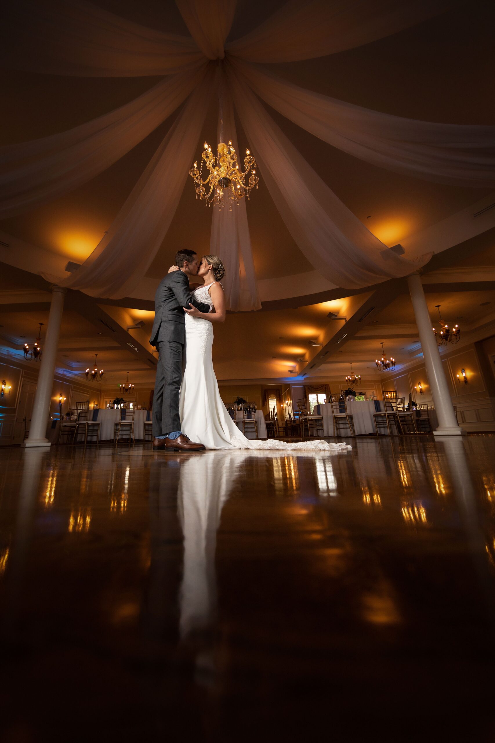 Newlyweds kiss while standing in the river house events wedding reception hall