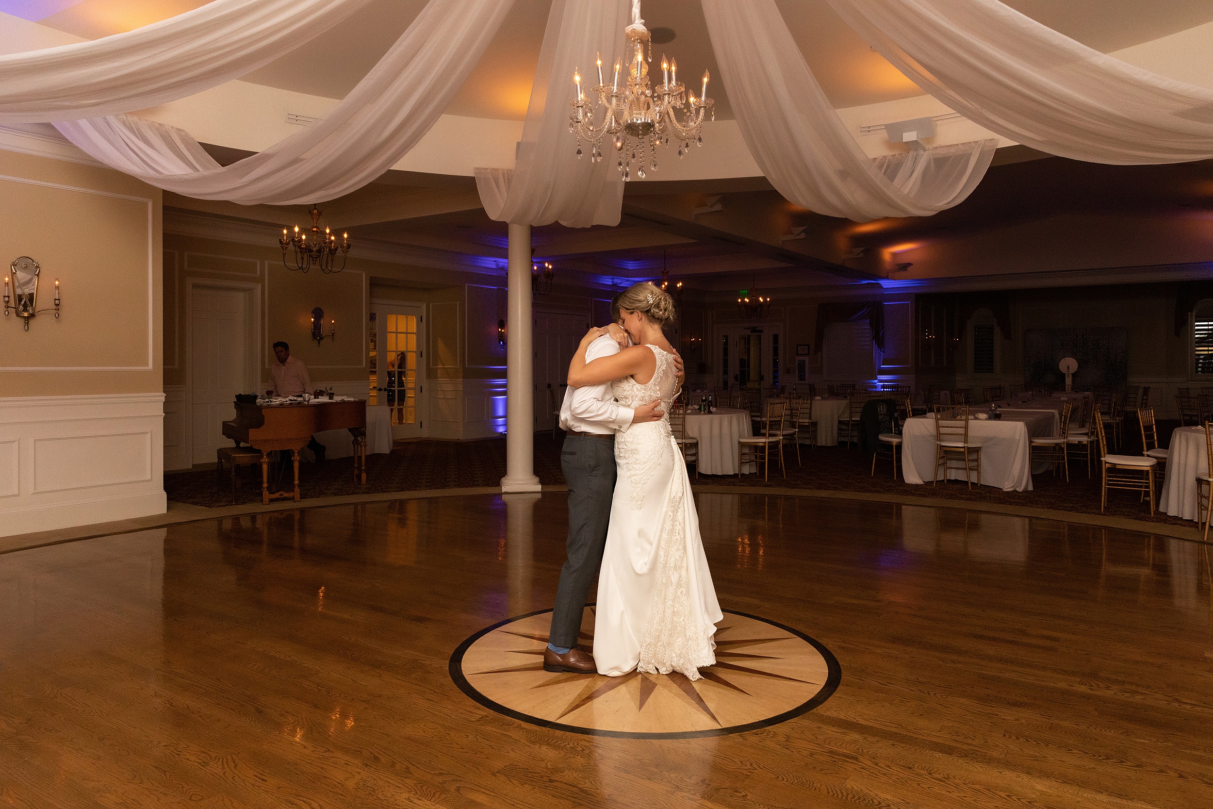 Newlyweds dance close in the center of their river house events wedding reception dance floor