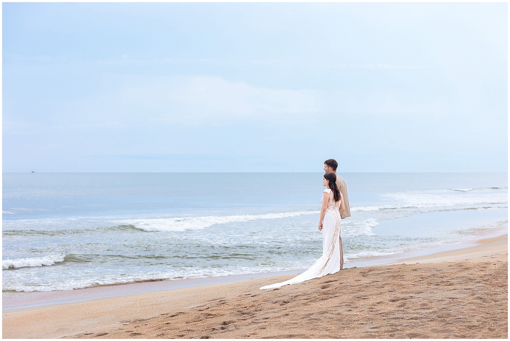 Newlyweds hold hands while staring off into the ocean at their serenata beach club wedding