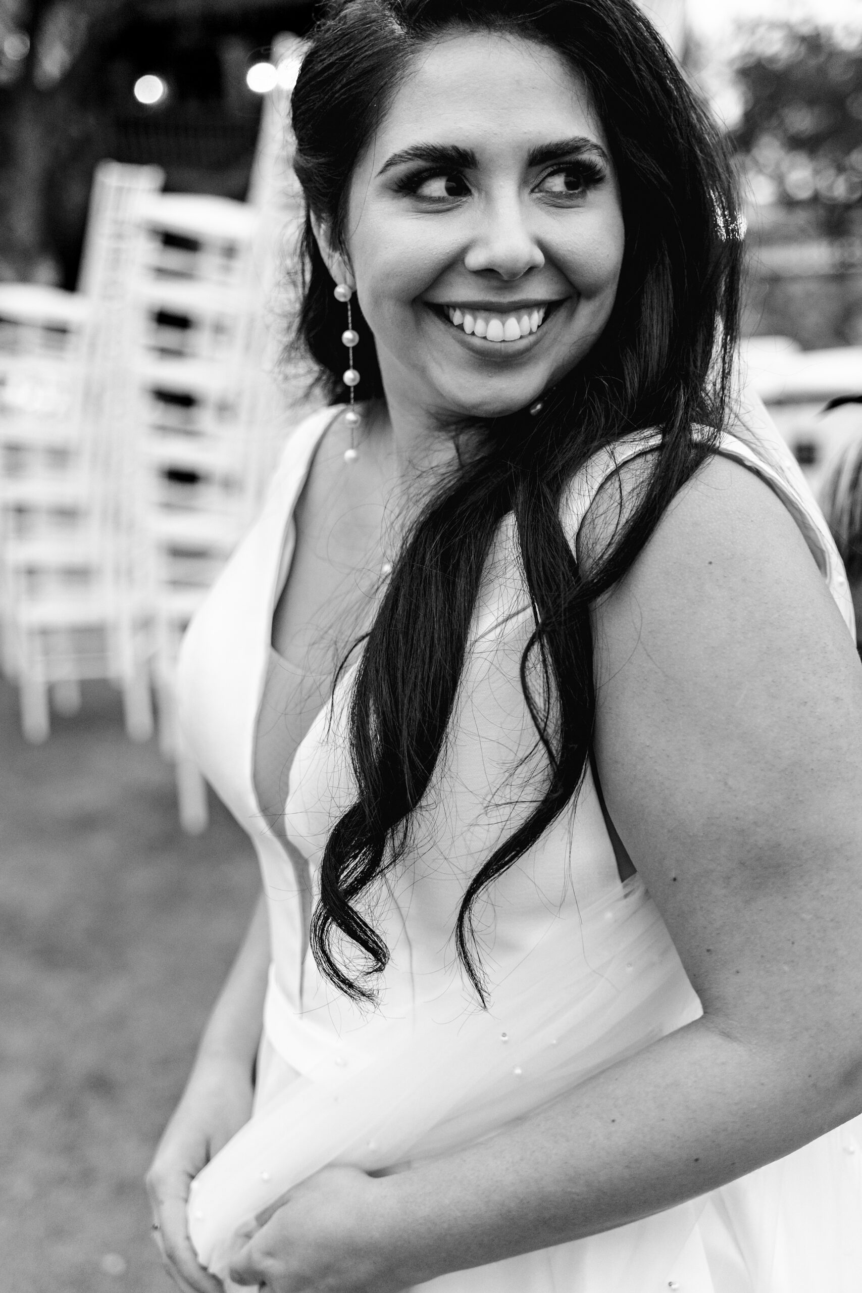 A bride in a silk dress smiles over her shoulder while standing in the garden at her st augustine historical society wedding
