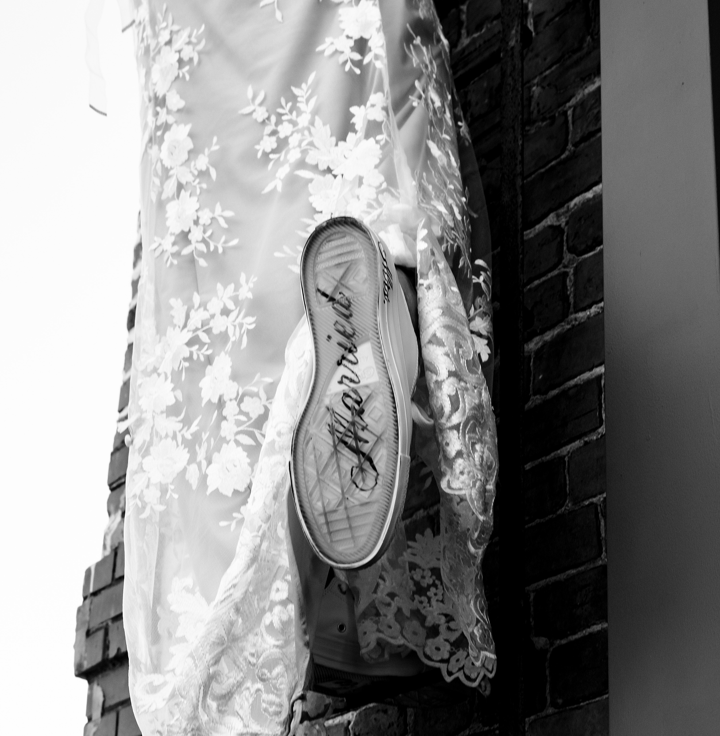 Details of a bride's custom shoe against a brick wall at the assembly room st augustine