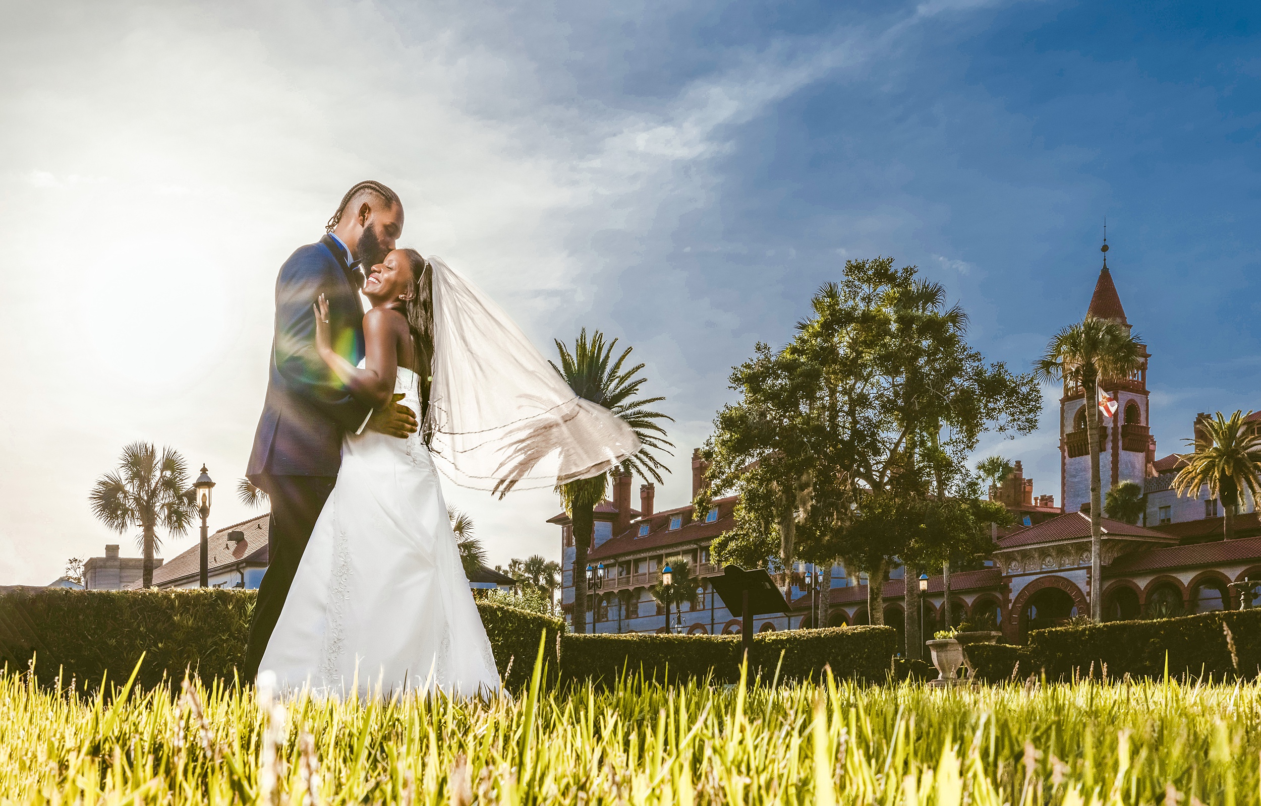 Newlyweds stand on a grassy lawn in the garden of the villa zorayda museum wedding venue