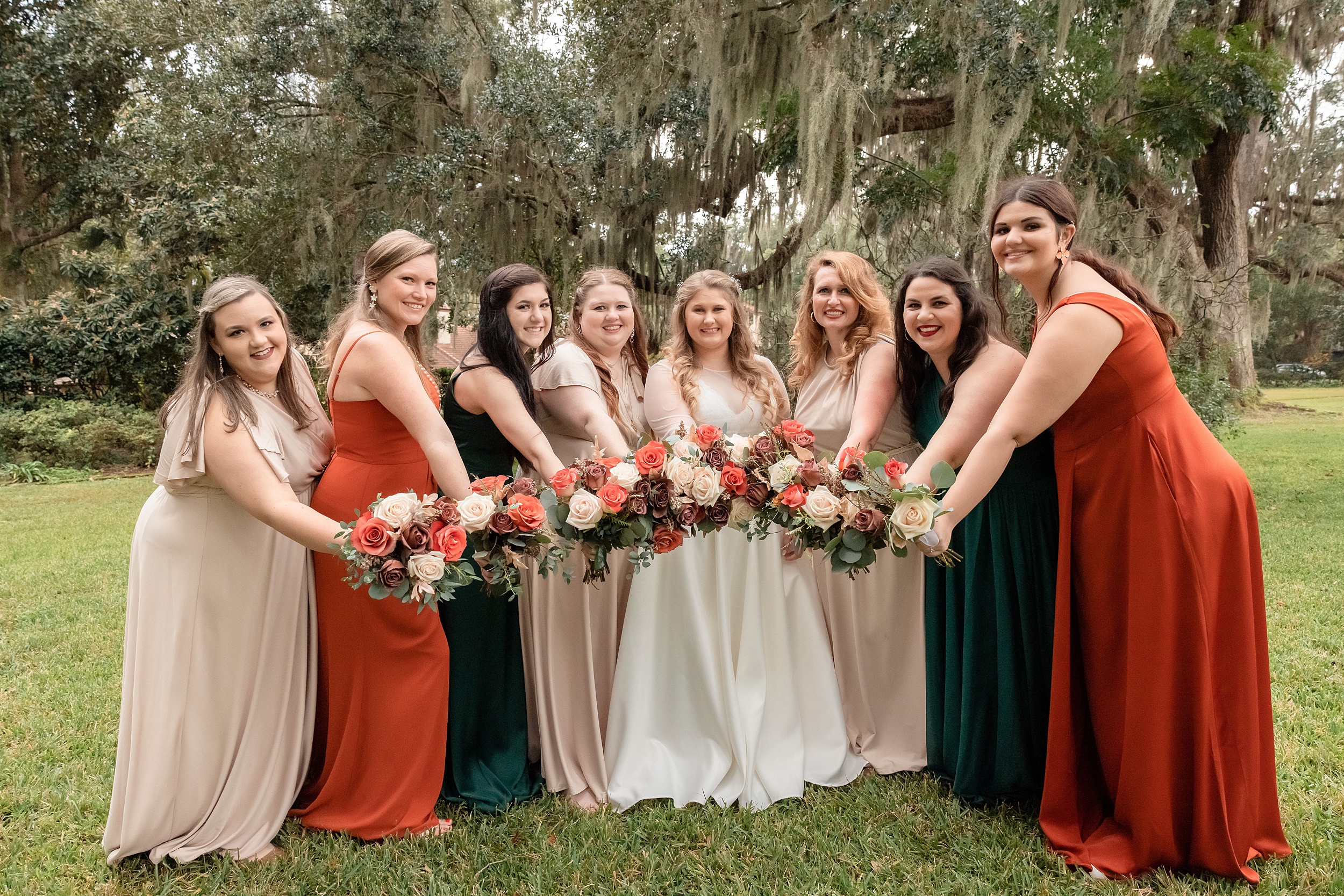 A bride shows off her bouquet with her bridesmaids