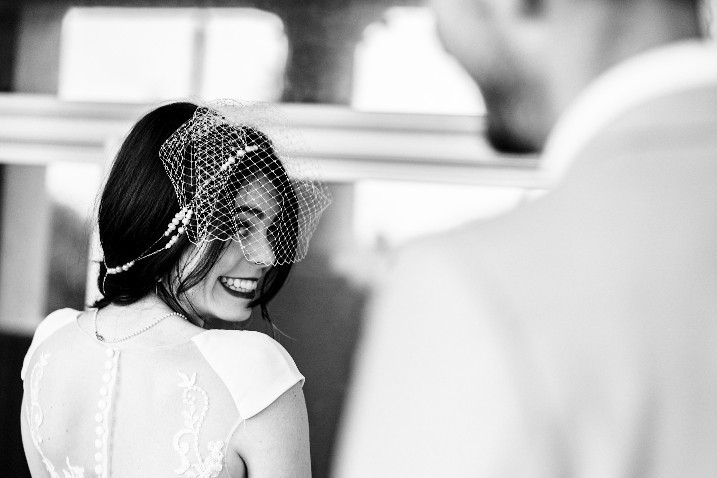 A bride smiles over her shoulder to her groom at their citrus club wedding