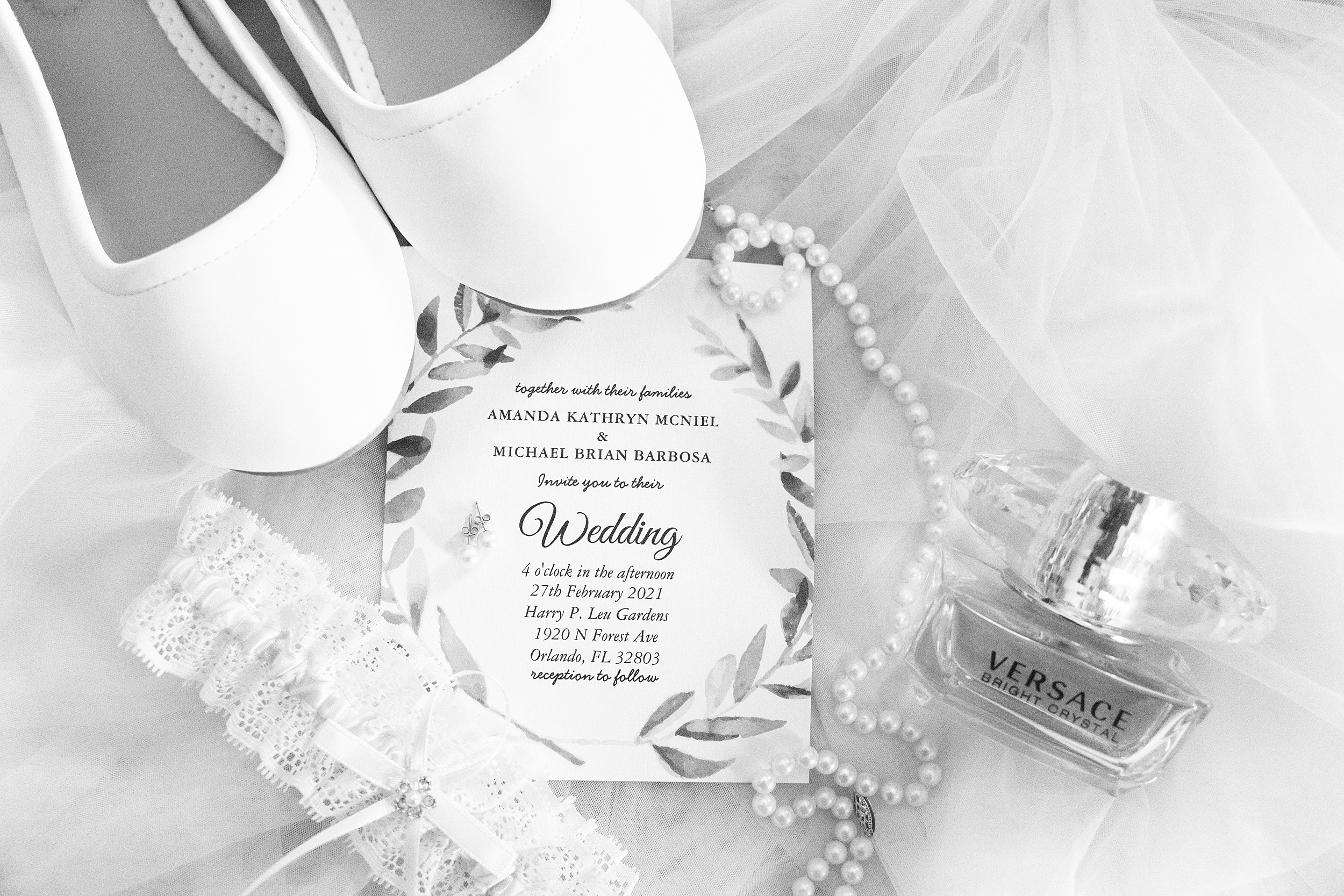 Details of a wedding invitation with bridal details on a table covered with a veil