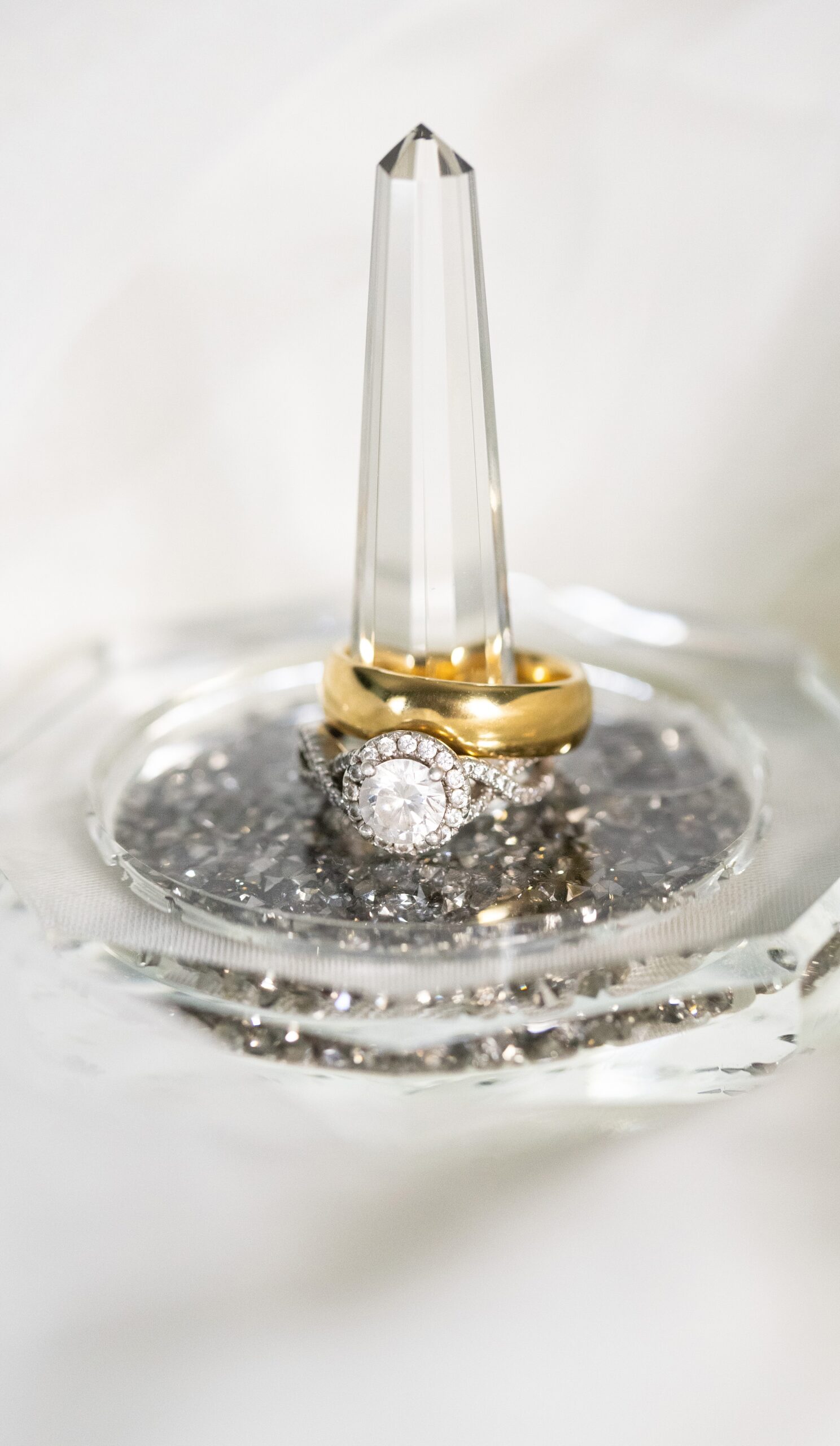 Details of wedding rings sitting on a glass pedestal