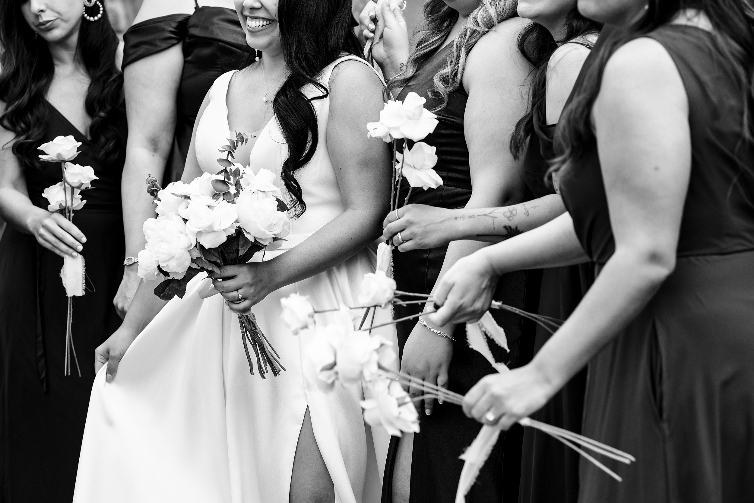 Details of a bride holding her white rose bouquet with her bridesmaids at her mission inn resort wedding