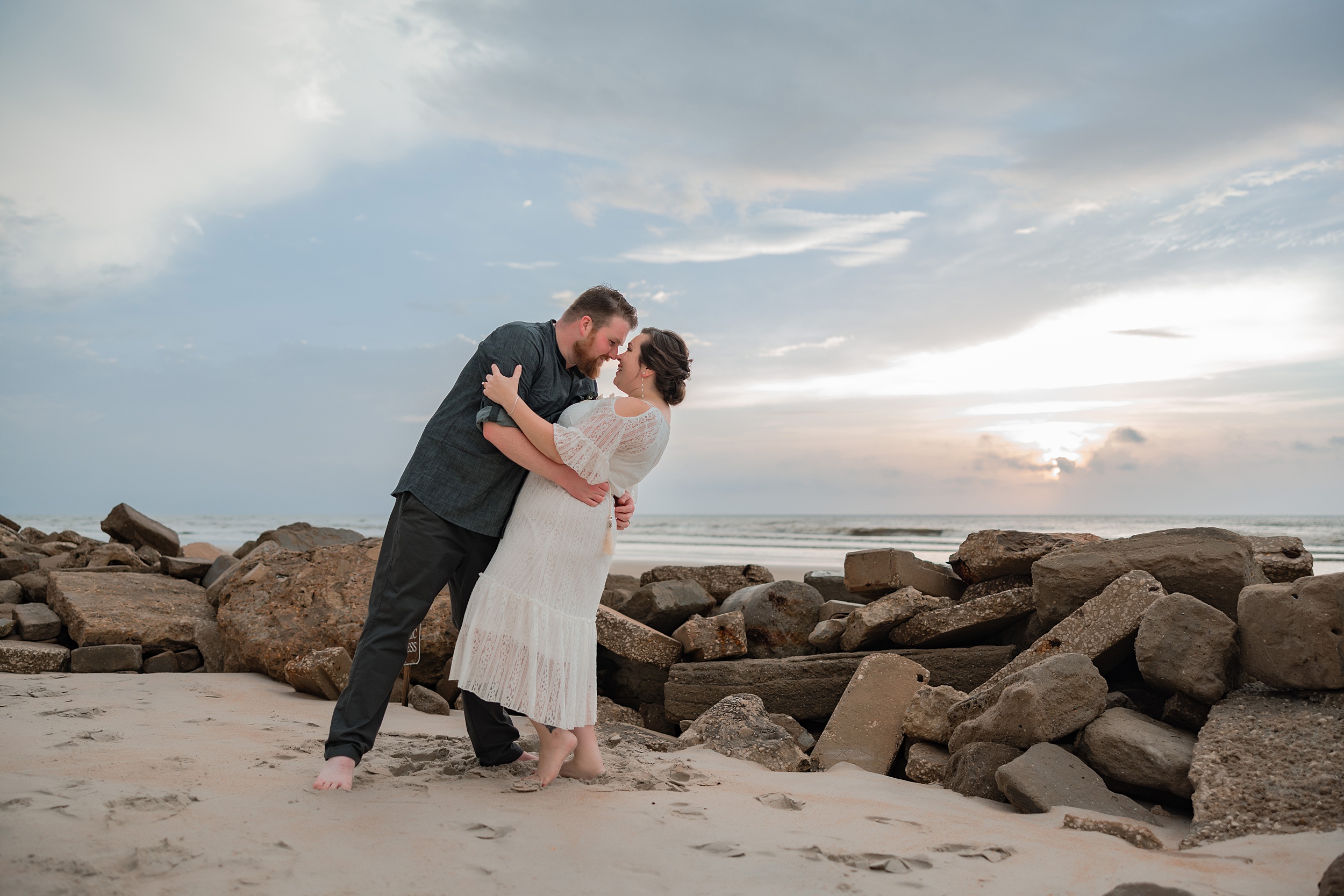 Newlyweds dip and kiss while standing at one of the st augustine beach wedding venues