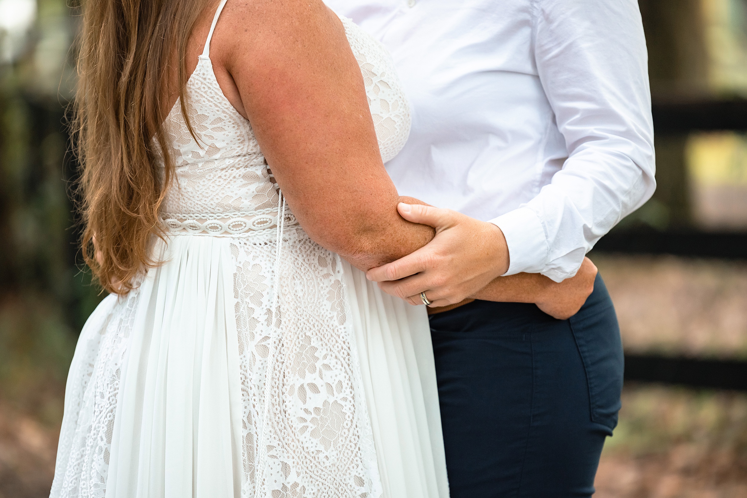 Details of newlyweds holding each other while standing outside the carriage house st augustine