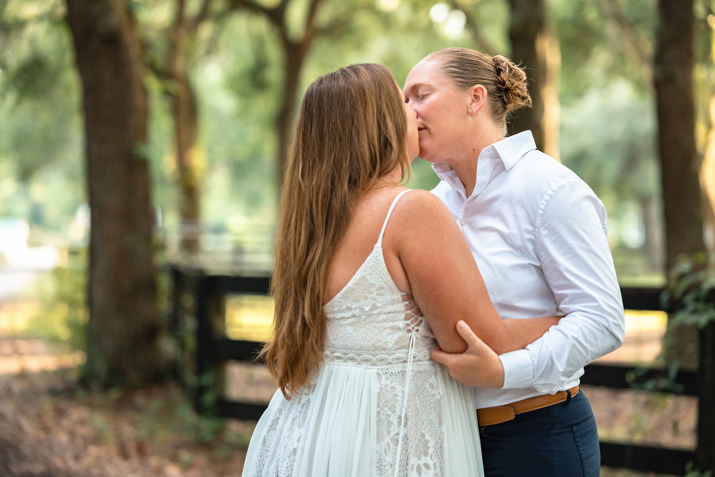Newlywed brides kiss while standing in a forest at their the carriage house st augustine wedding