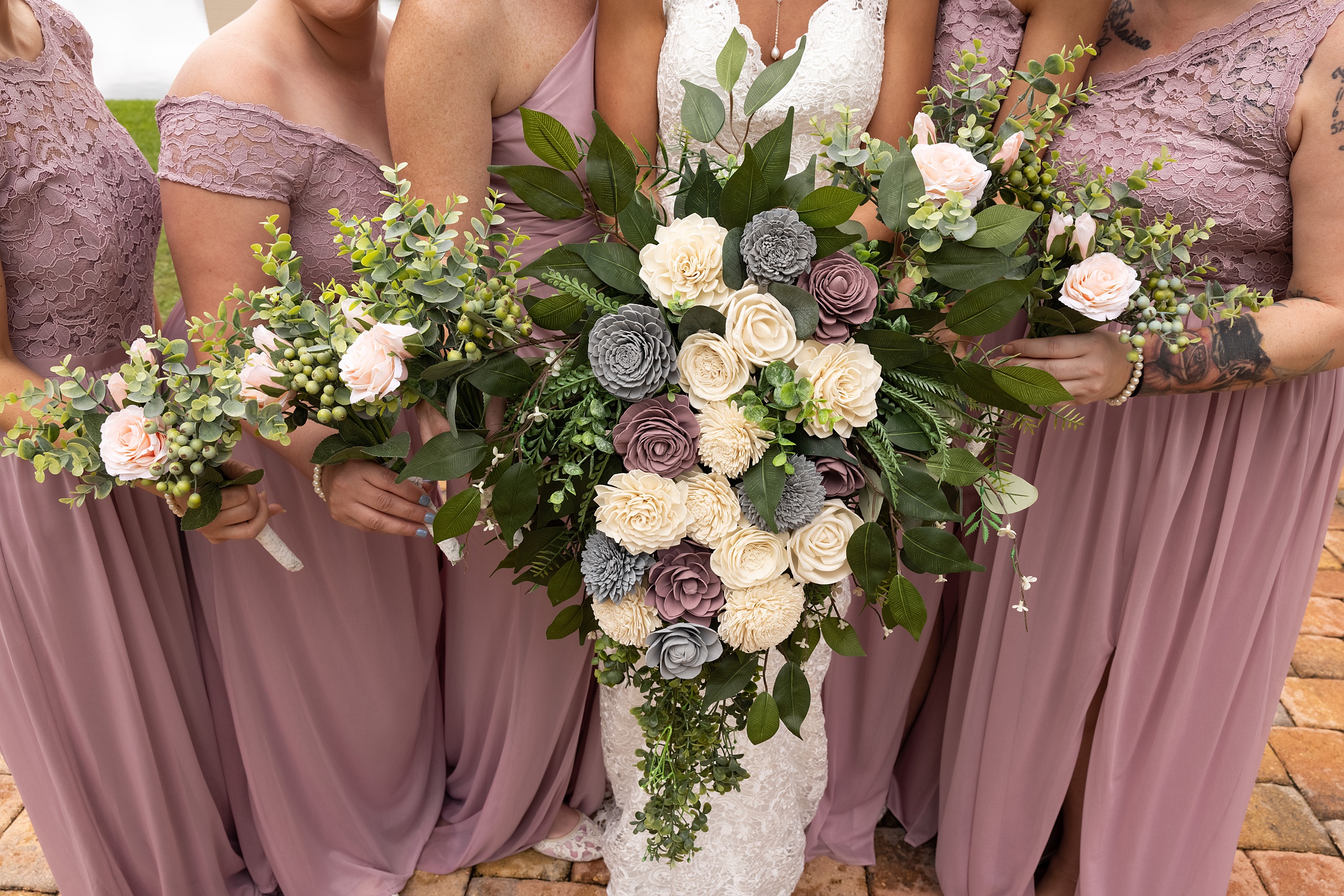 Details of a bride's large colorful bouquet with her bridesmaids