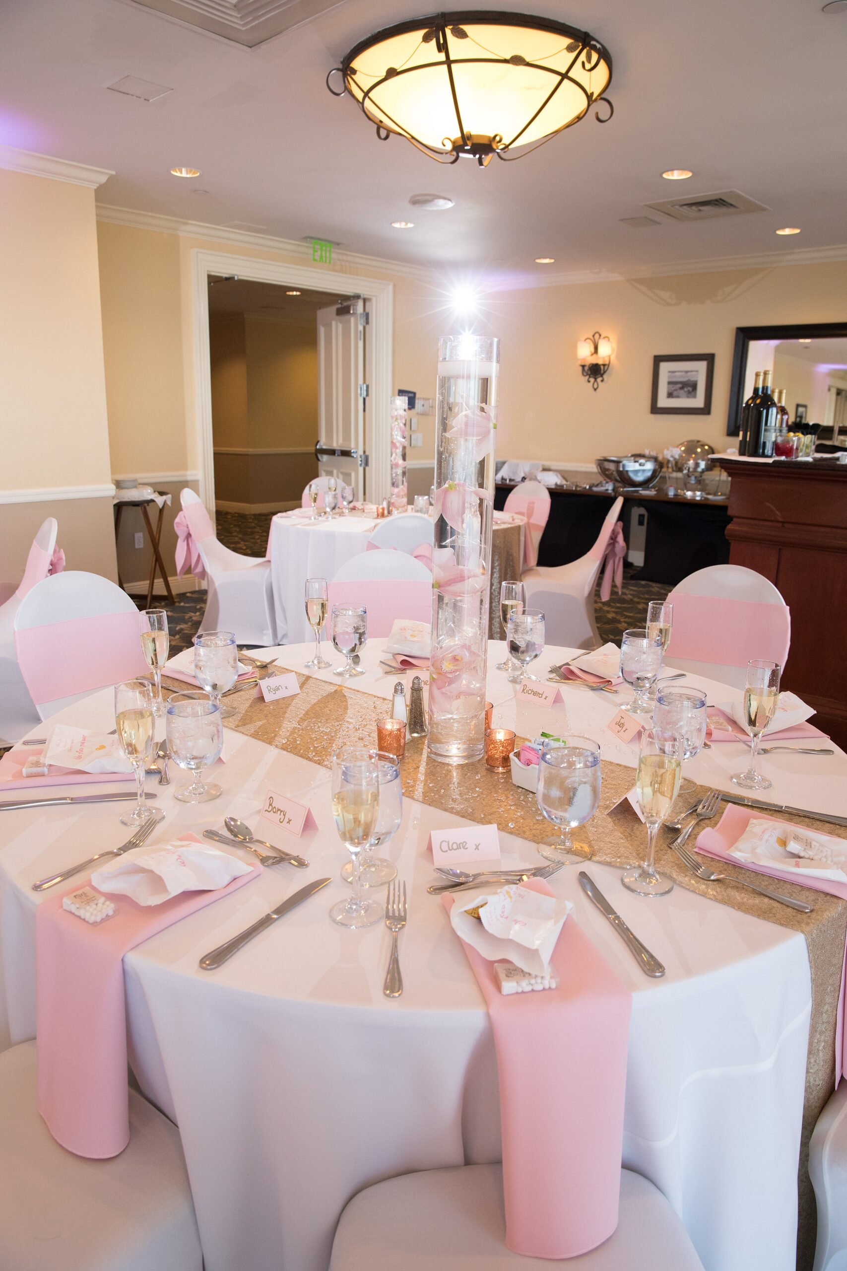 Details of a wedding reception table set up with pink napkins