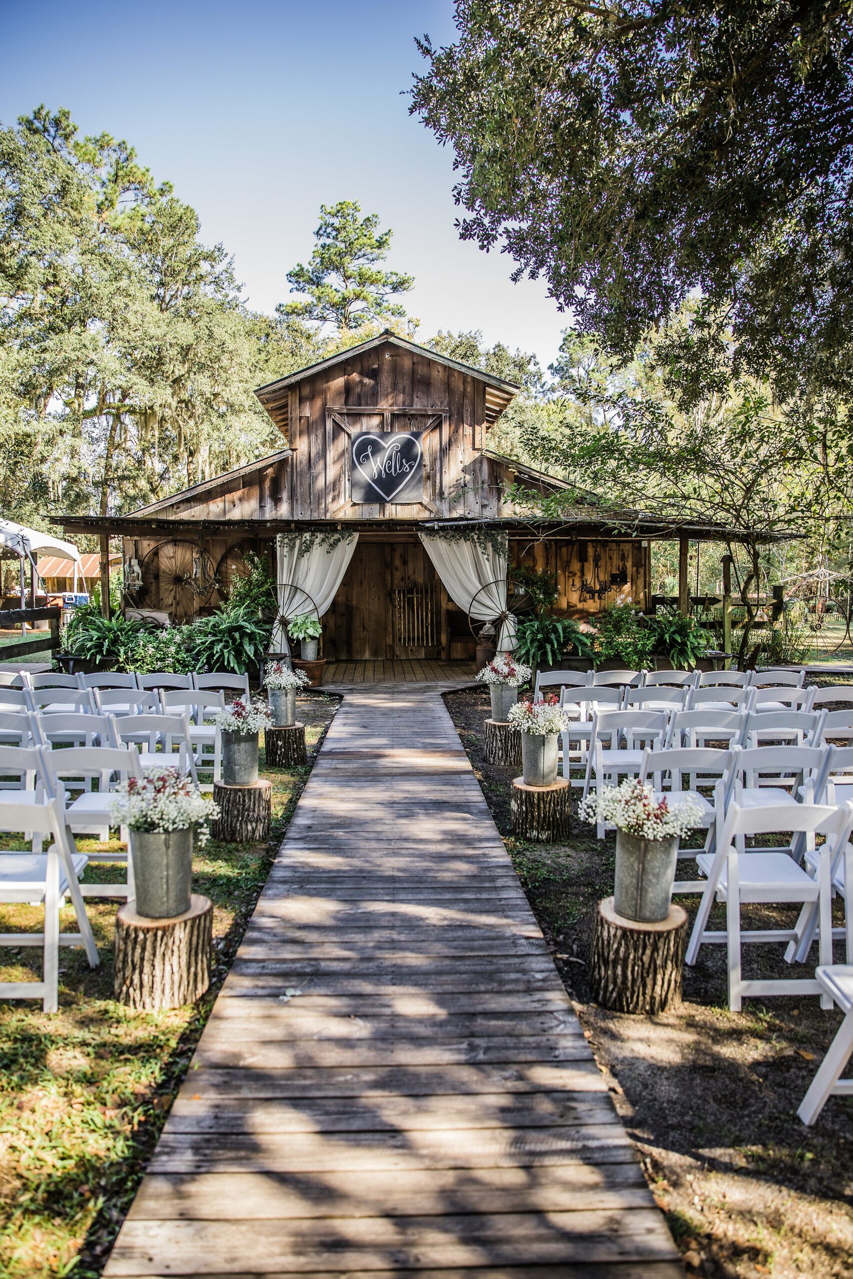 Details of white chairs and flowers set up for a rustic Florida wedding ceremony