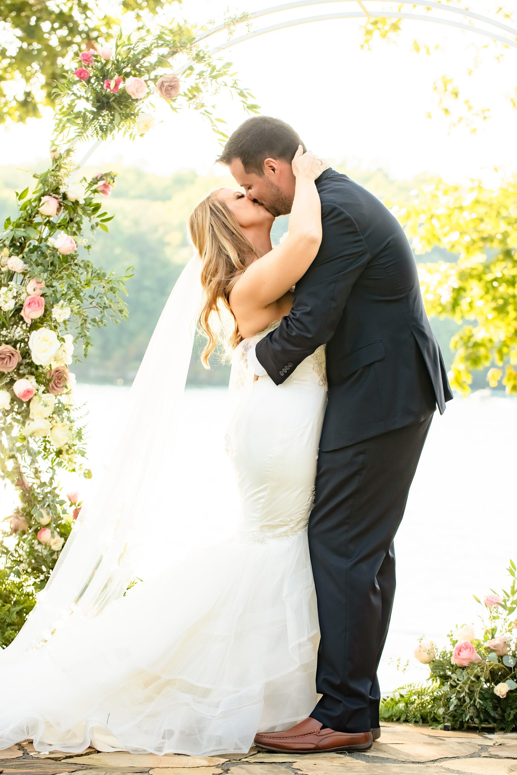 Newlyweds kiss under the round floral arbor at their world golf village wedding