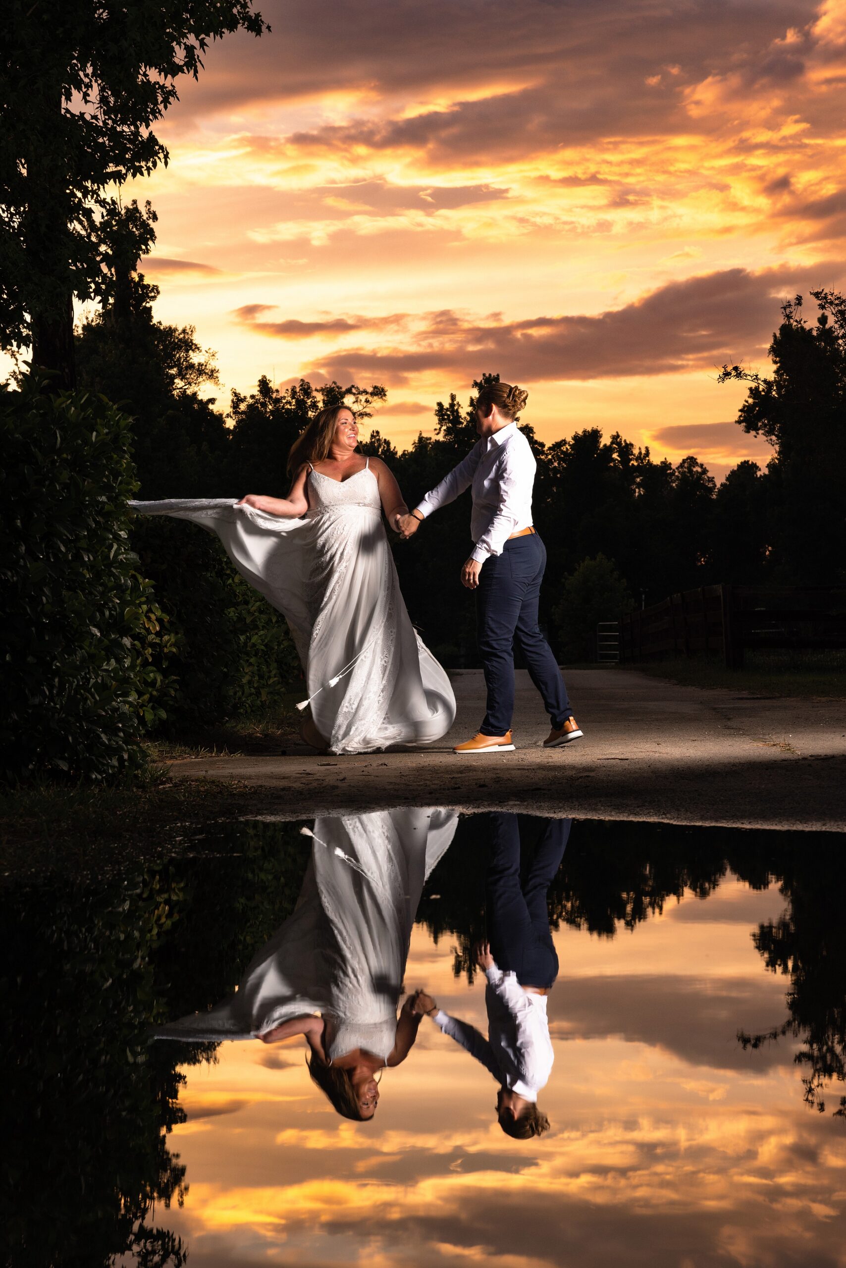 Newlyweds play in a garden at sunset while holding hands