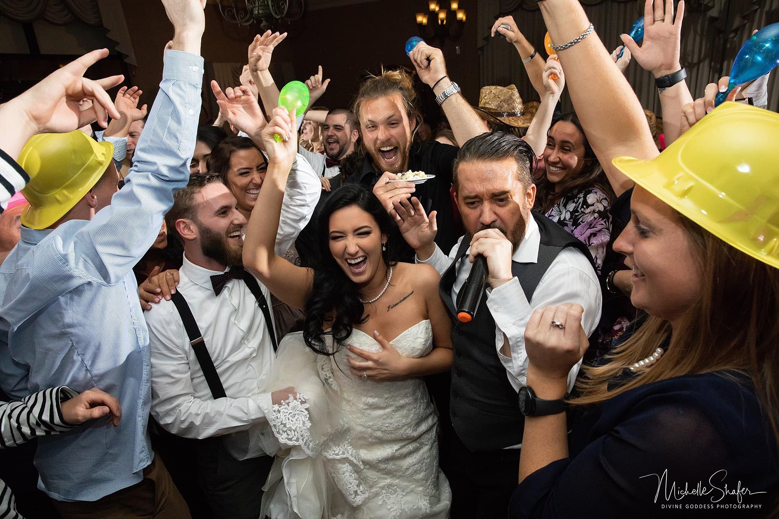 Newlyweds dance and celebrate with their DJ on the dance floor thanks to orlando wedding planners