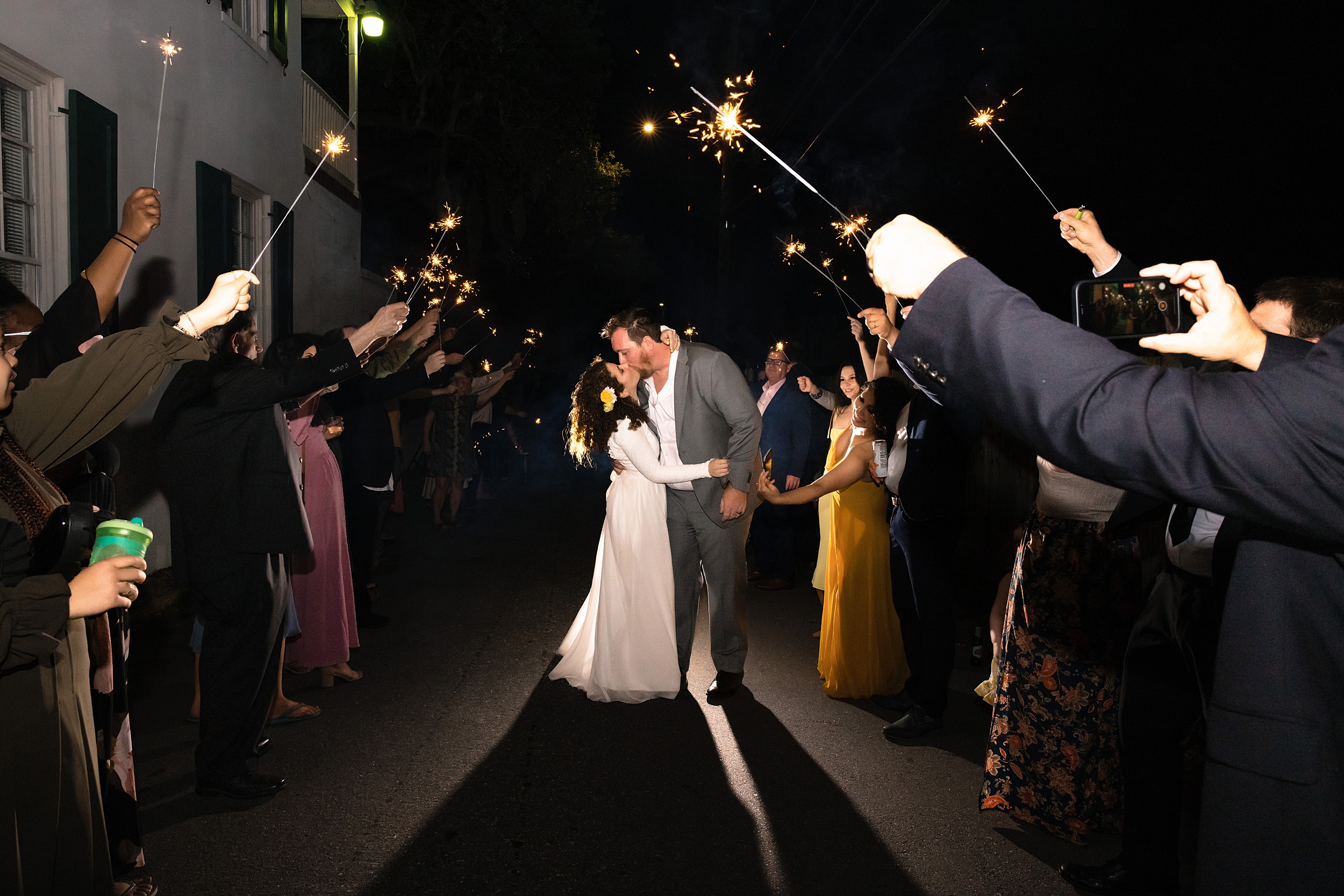 Newlyweds kiss under a shower of sparklers while exiting their wedding at one of the orlando wedding venues