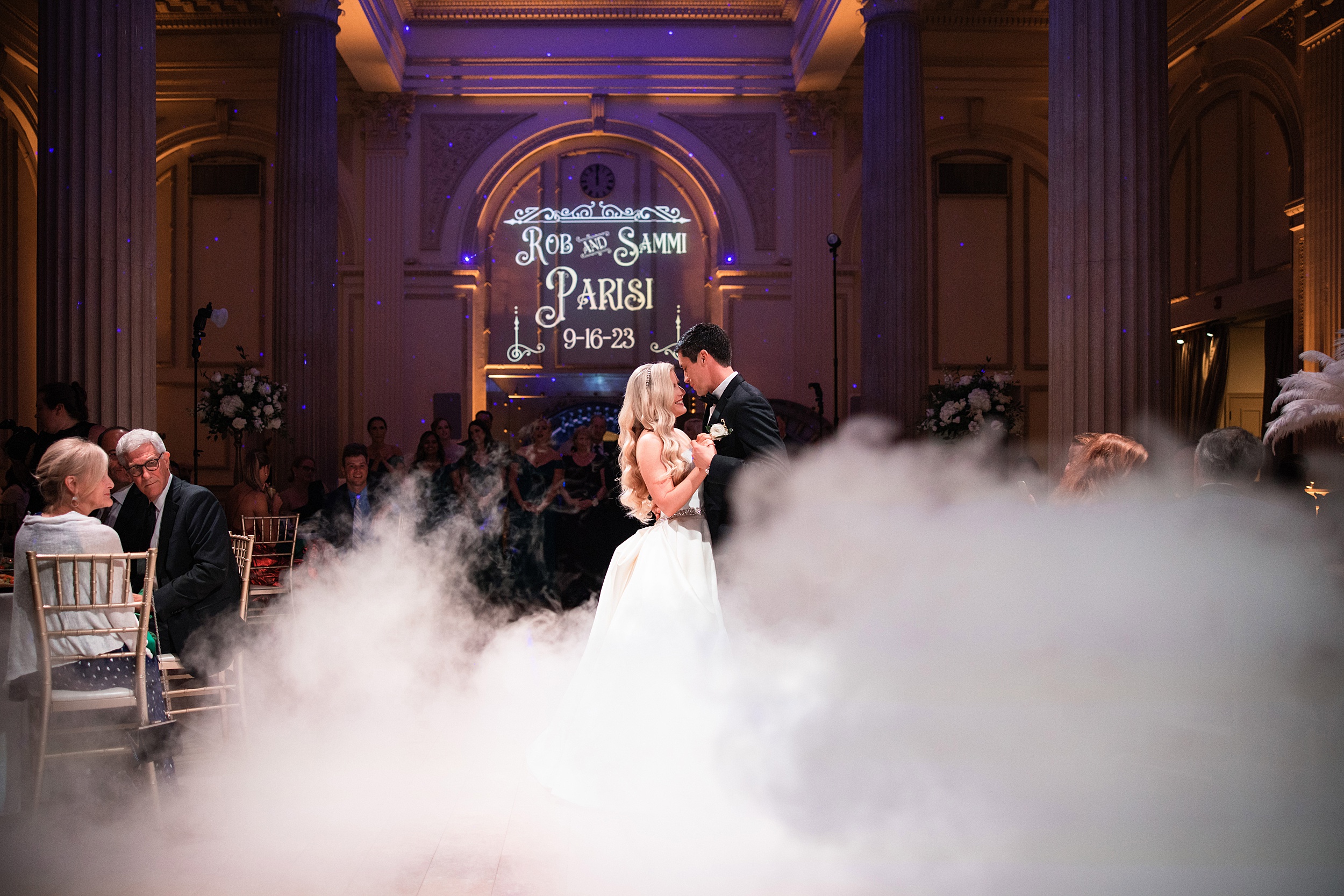 Newlyweds dance on a smoke filled dance floor surrounded by guests with help from their st augustine wedding planners