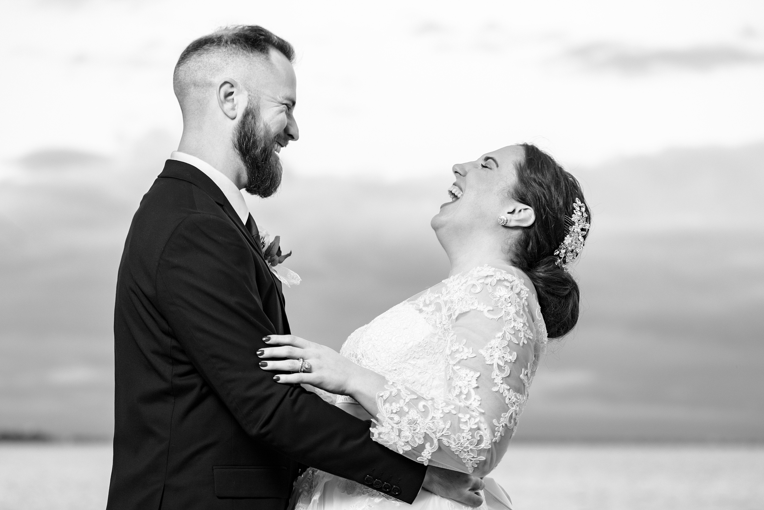Newlyweds smile and laugh while hugging during their the capen house wedding
