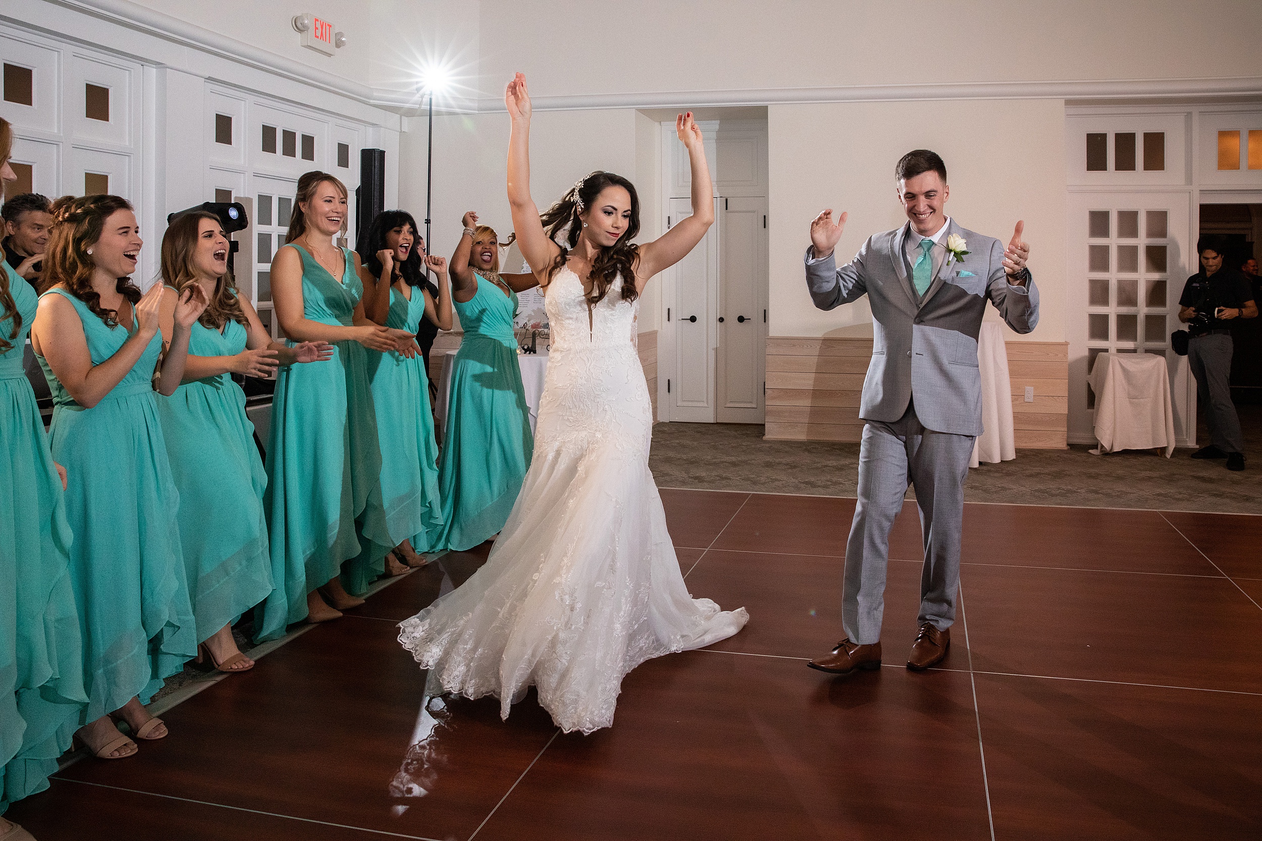 A bride and groom command a dance floor with their bridal party for the first time as a married couple