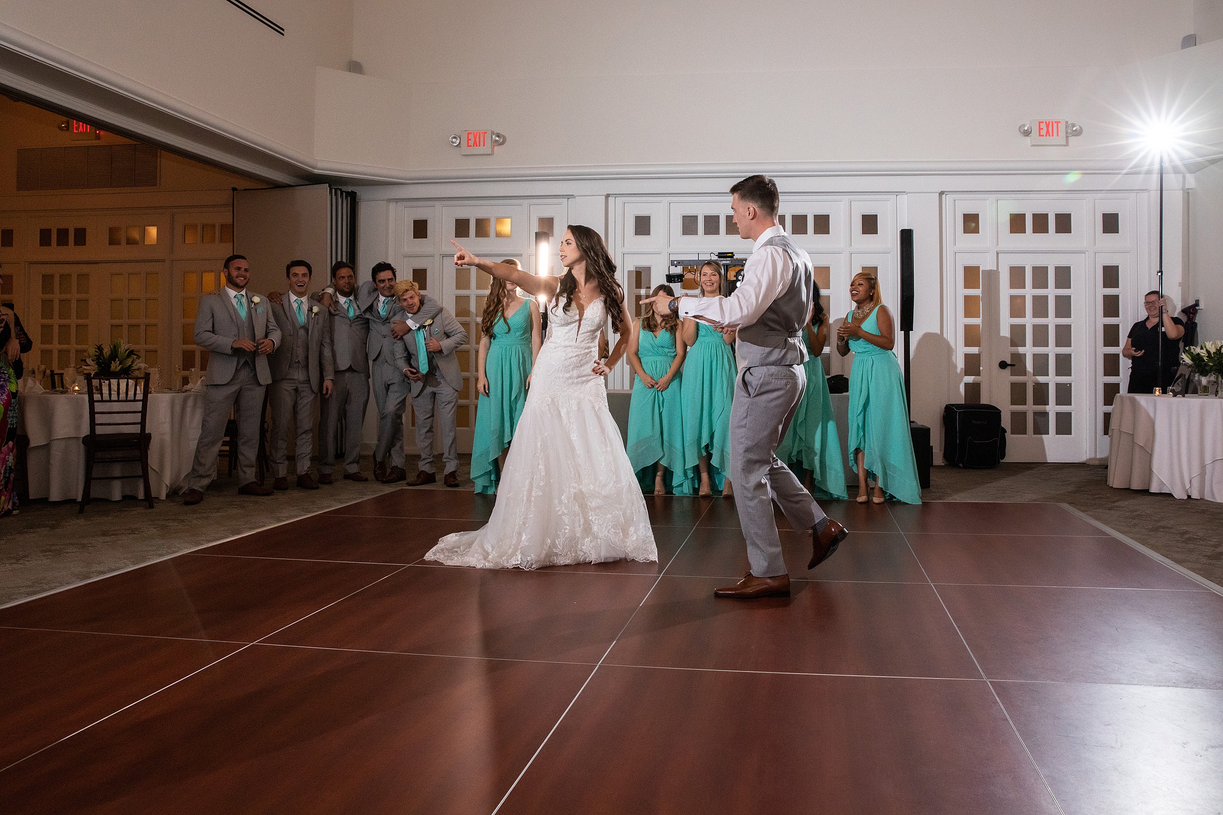 Newlyweds dance and celebrate on the dance floor with their wedding party cheering them on