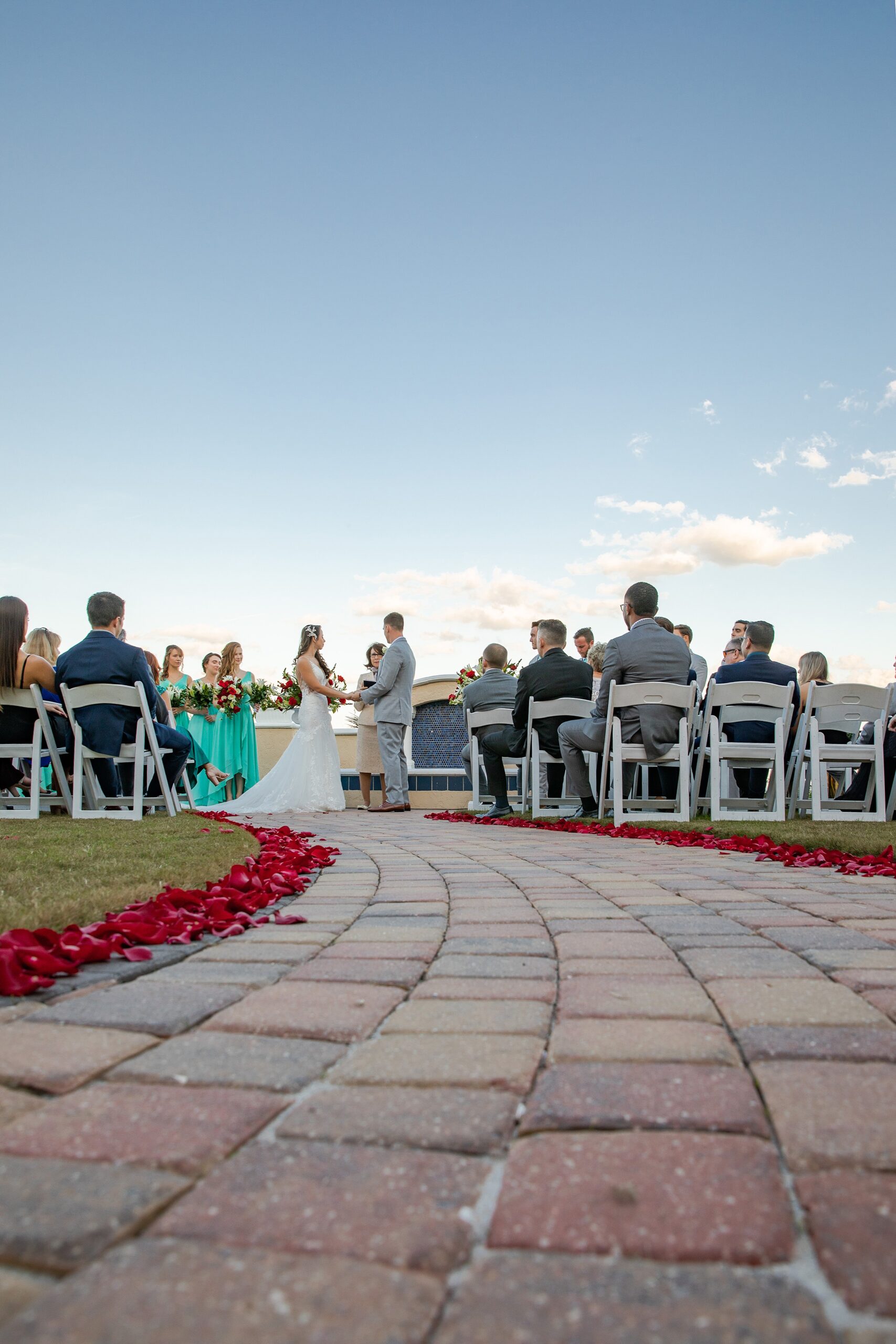 A view up the aisle at a wedding ceremony on a brick lined path