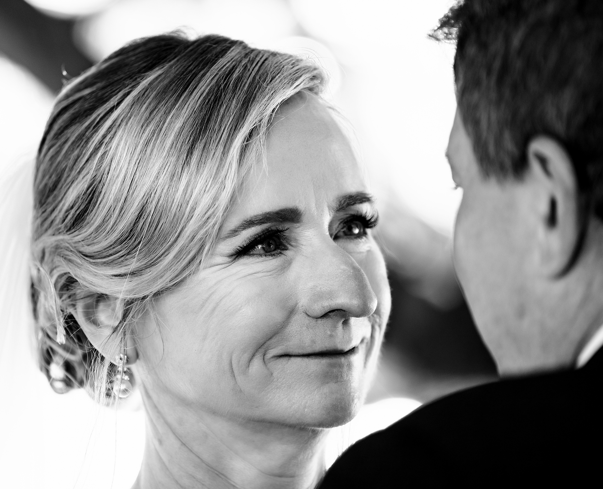 A happy bride smiles while looking into the eyes of her groom at their heathrow country club wedding